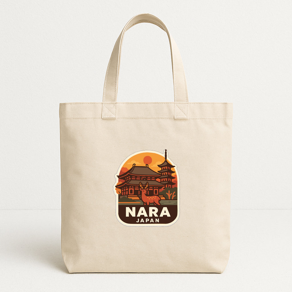 A beige tote bag with a graphic design featuring a temple and a deer, along with the text "NARA JAPAN".