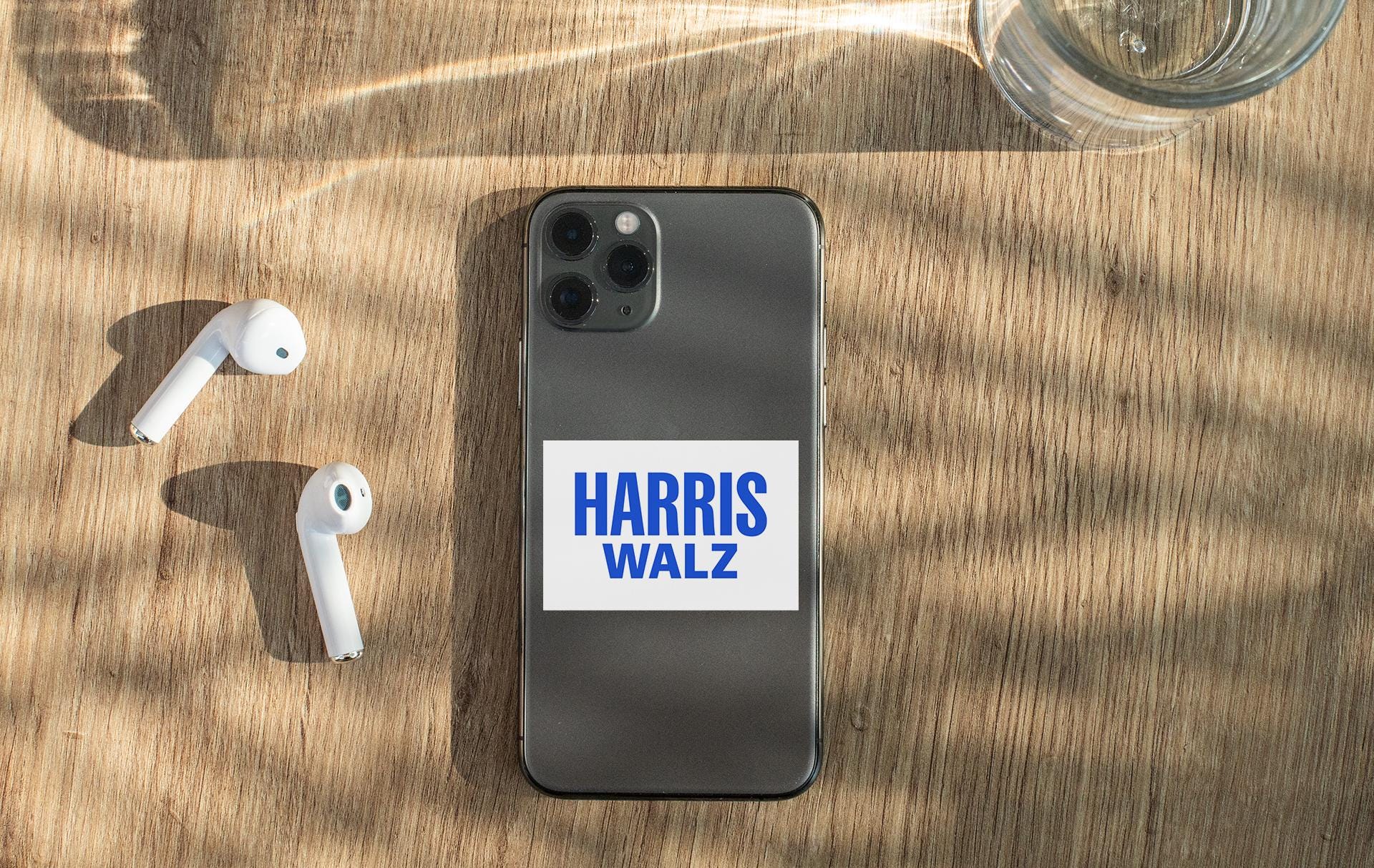 a phone with a sticker on it next to ear buds