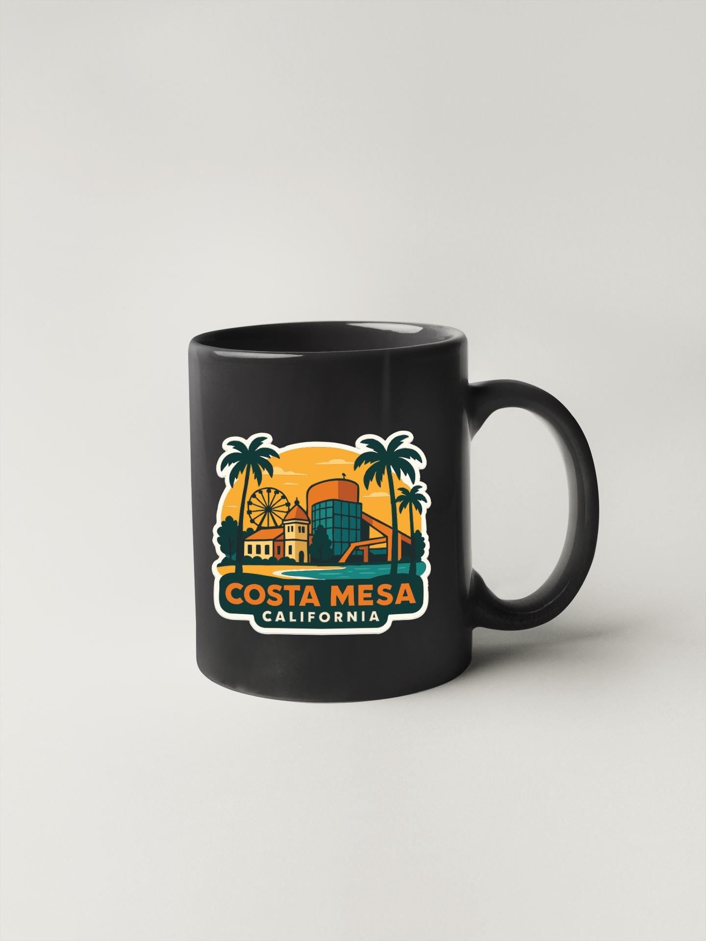 A black coffee mug with a colorful graphic design depicting a cityscape and palm trees, along with the text "Costa Mesa, California".