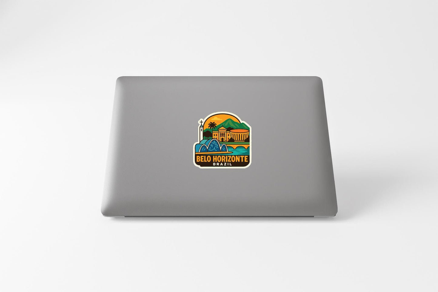 a sticker on the back of a laptop, depicting a tropical beach scene with palm trees and a sunset.
