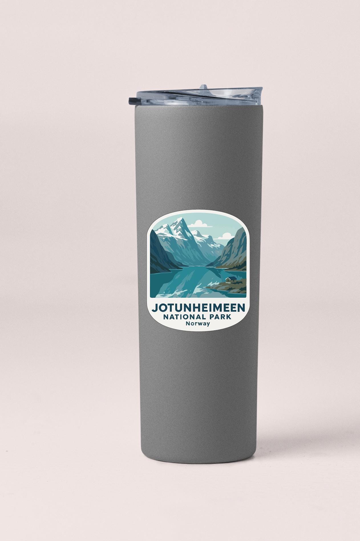 A gray insulated tumbler with a sticker depicting a scenic mountain landscape and the text "JØTUNHEIMEEN NATIONAL PARK NORWAY".