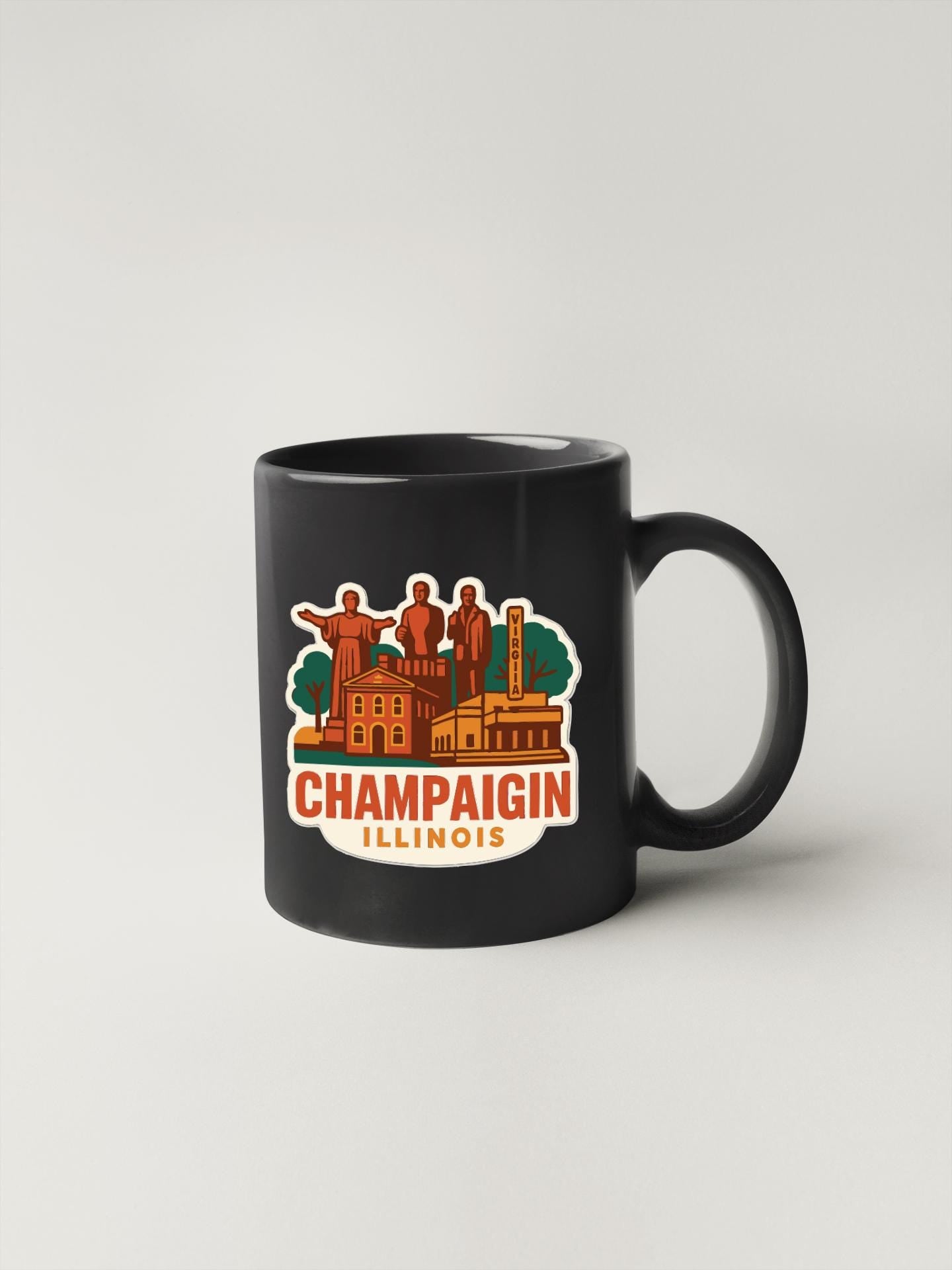 A black coffee mug with a colorful graphic depicting the Champaign, Illinois area.
