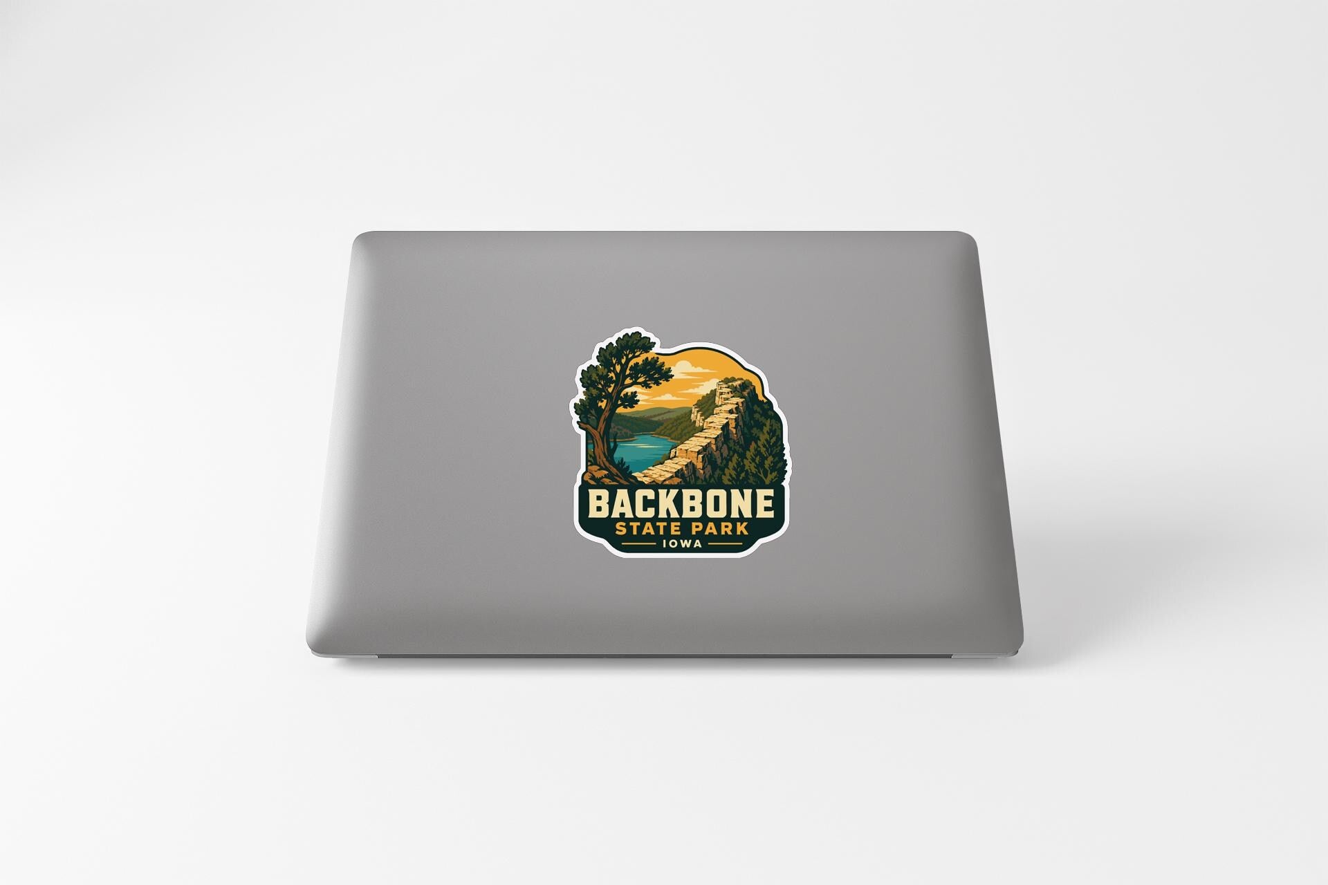 a sticker with a scenic landscape and the text "BACKBONE STATE PARK" printed on a laptop.