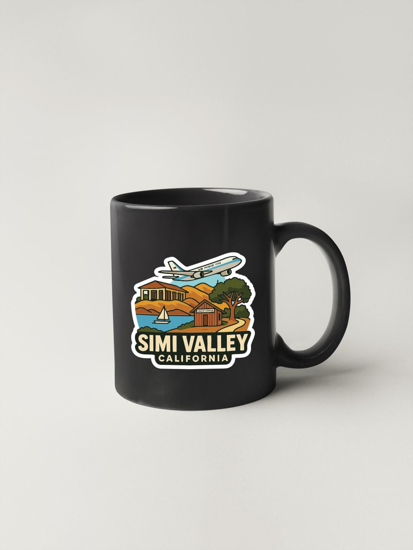 A black coffee mug with a colorful illustration depicting landmarks and scenery from Simi Valley, California.
