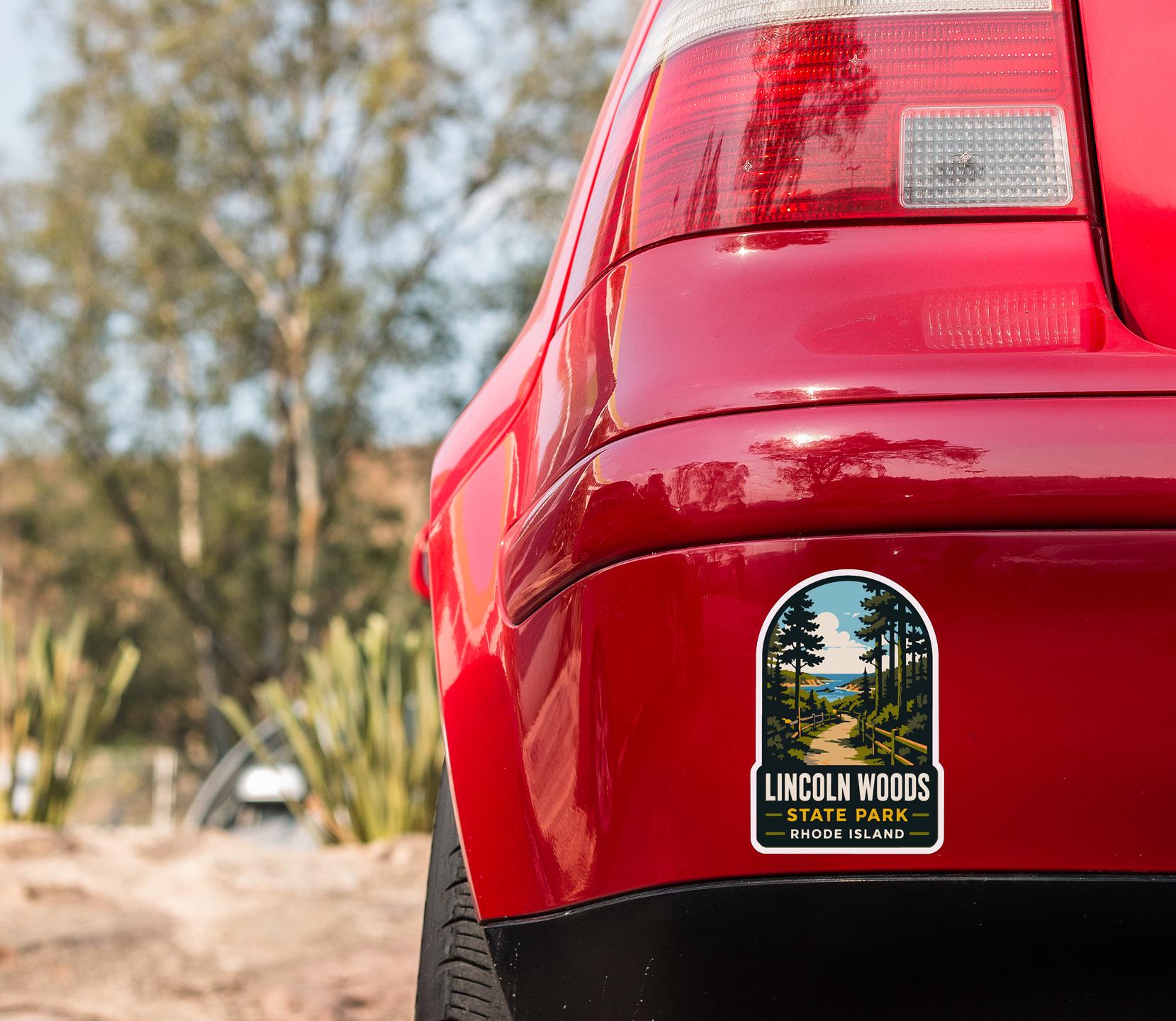 the rear end of a red car with a sticker on the back window that says "Lincoln Woods State Park, Rhode Island".