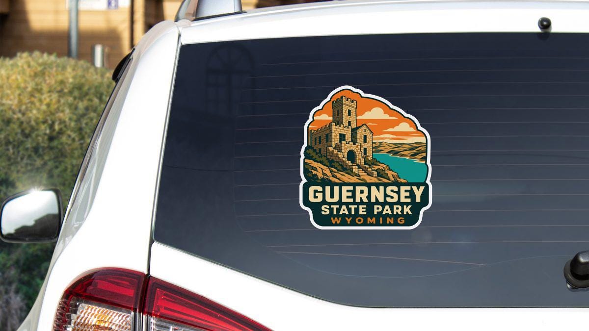 a sticker on the rear window of a vehicle, depicting a scenic landscape with a castle or tower in the background.