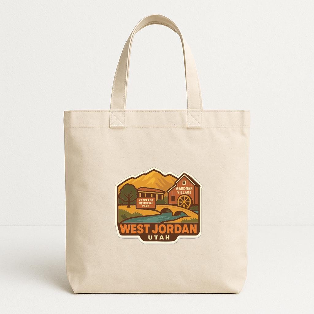 A beige tote bag with a graphic design depicting a scenic landscape with mountains, a building, and a river.