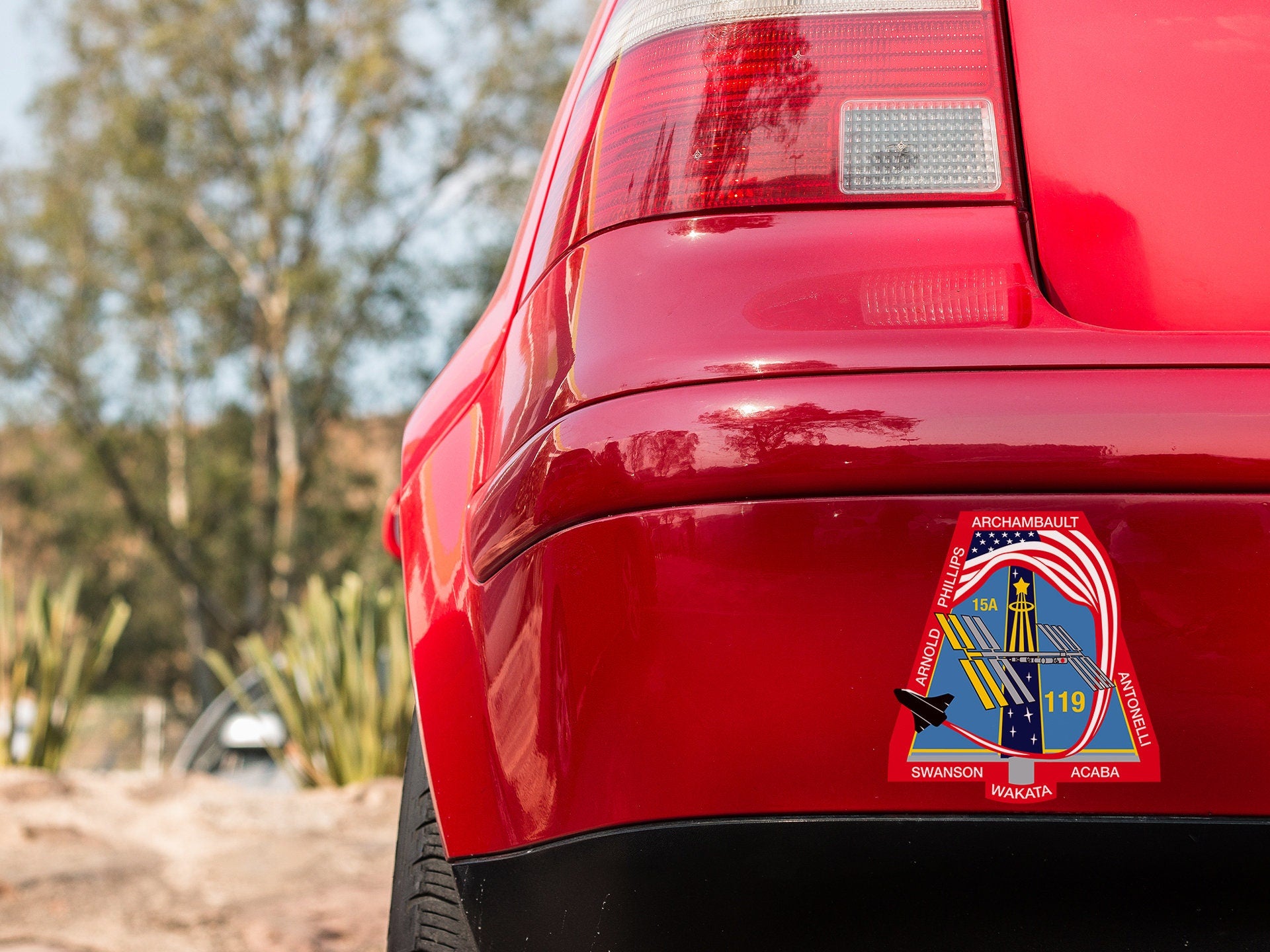 a close up of a red car with a sticker on it