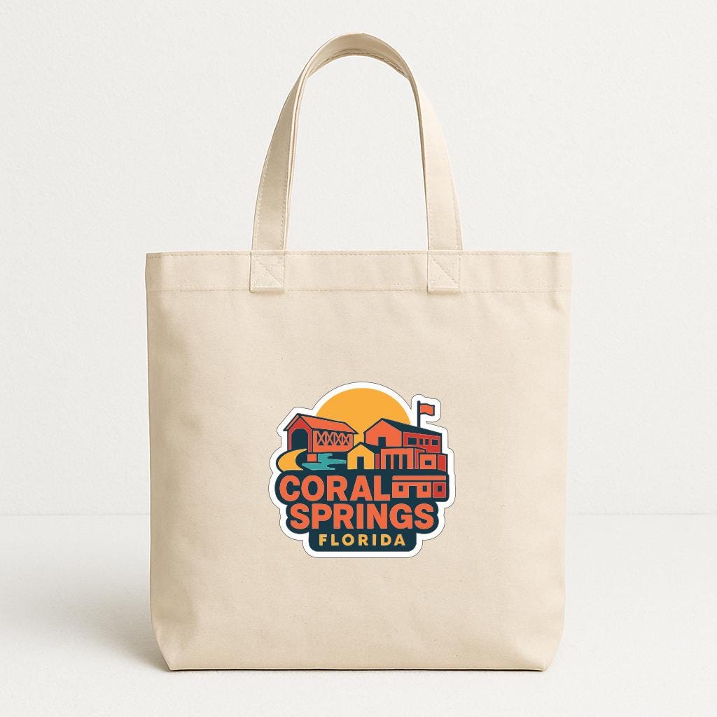 A beige tote bag with a colorful graphic design featuring a stylized illustration of a building and the text "CORAL SPRINGS FLORIDA".