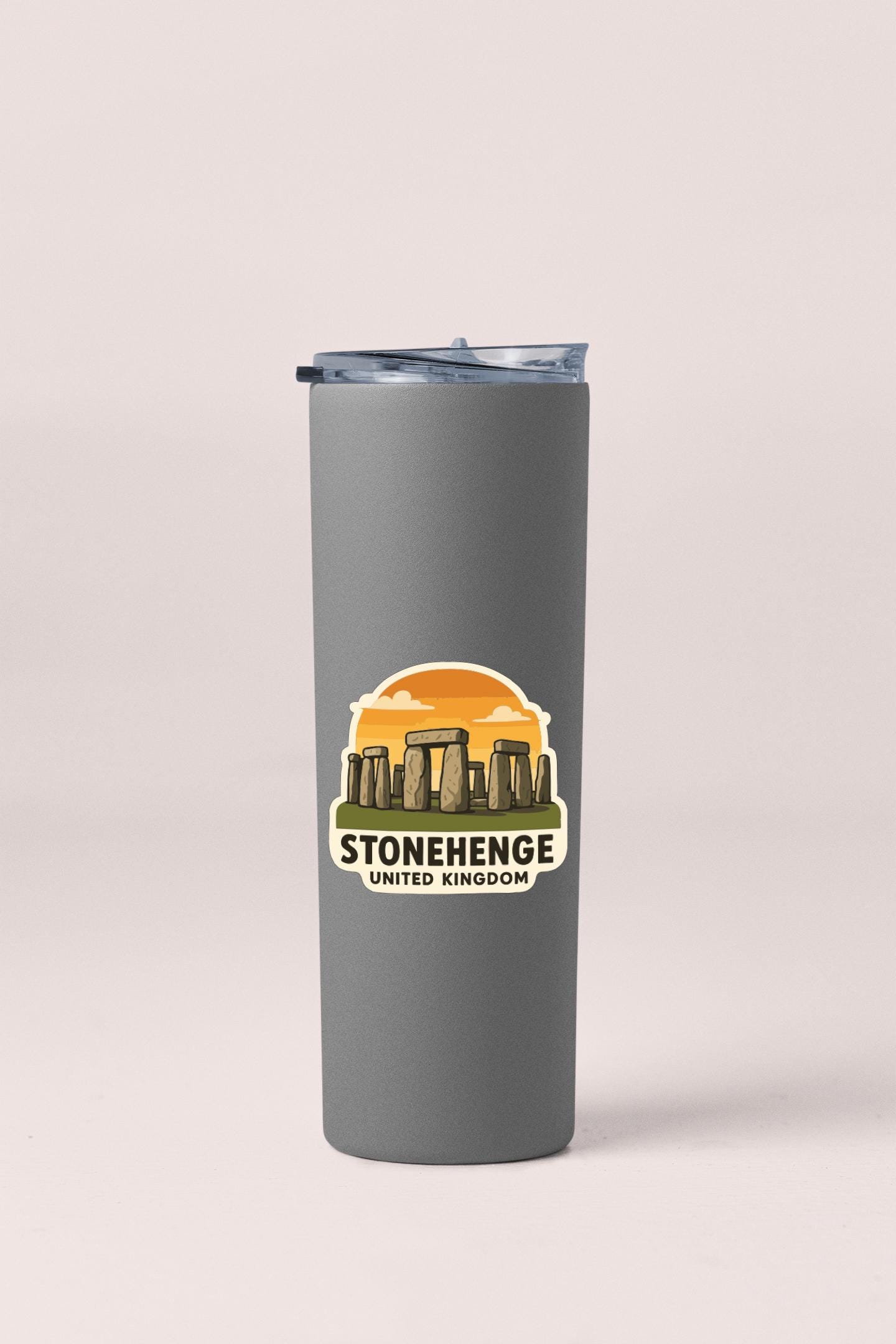 A gray insulated tumbler with a sticker depicting Stonehenge and the text "STONEHENGE UNITED KINGDOM".