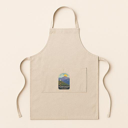 A beige apricot with a small graphic of a mountain and a blue sky on the front pocket.