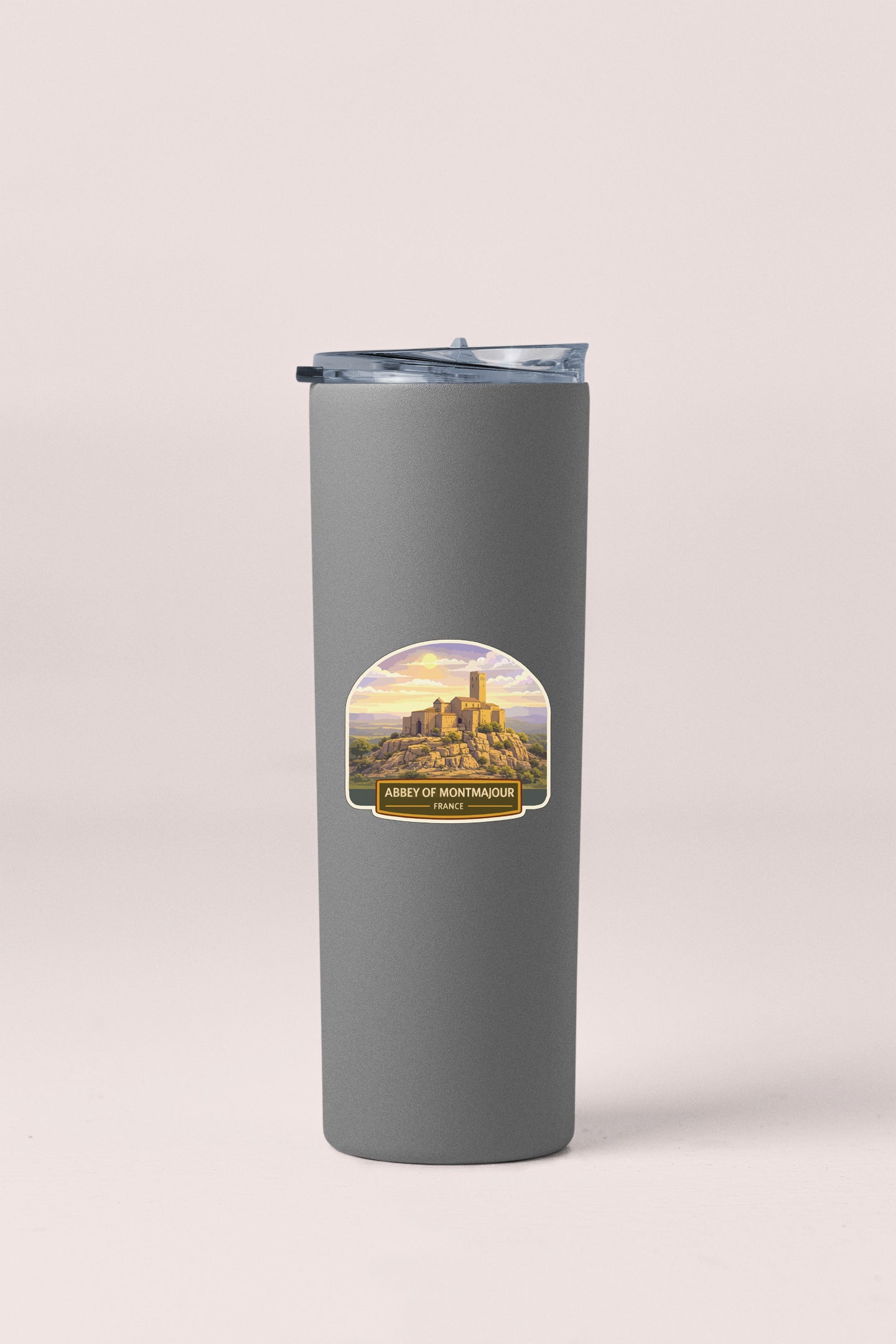 A gray insulated tumbler with a label depicting a castle in the background.
