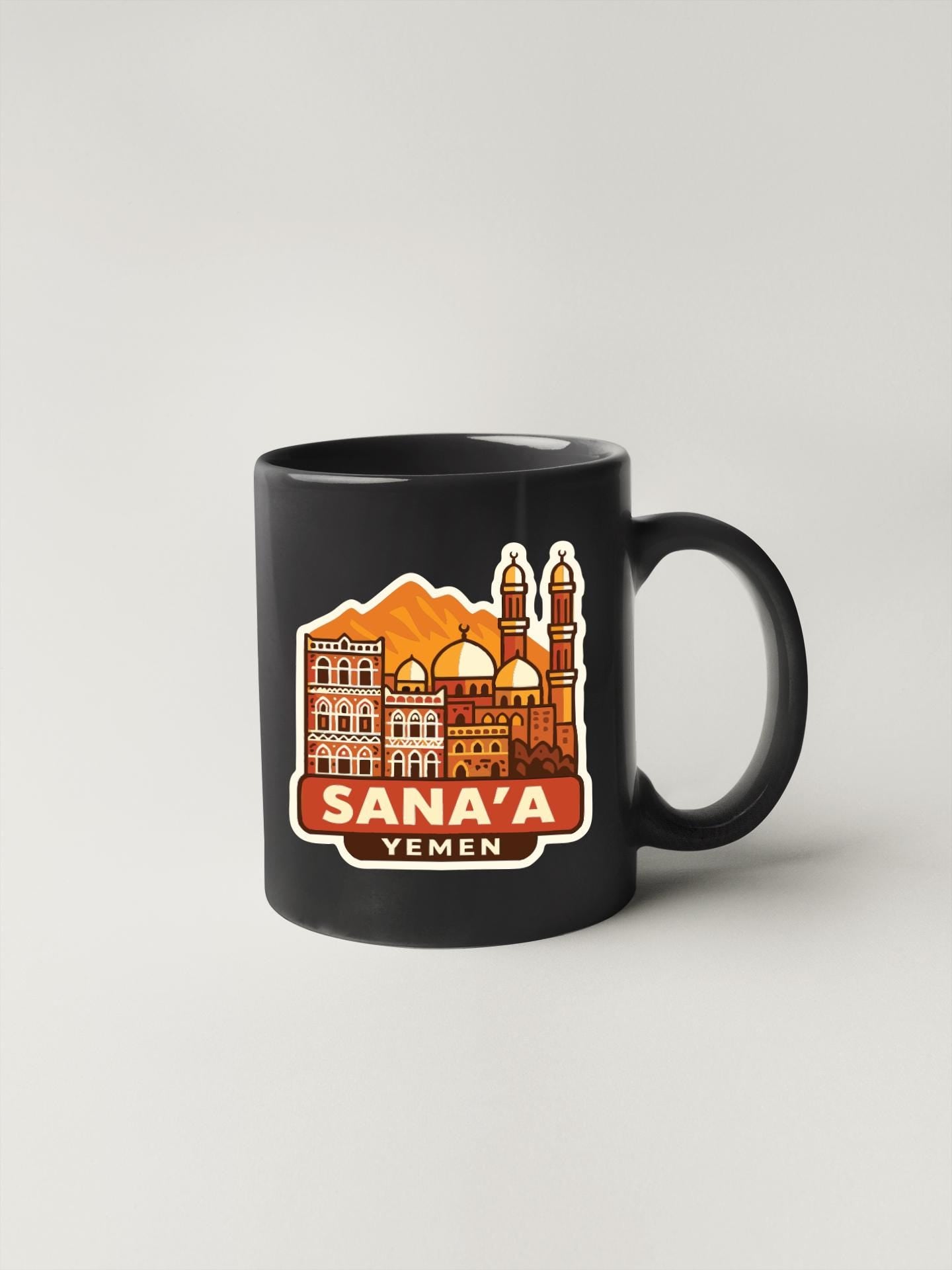 A black coffee mug with an illustration of the Sana'a skyline in Yemen.
