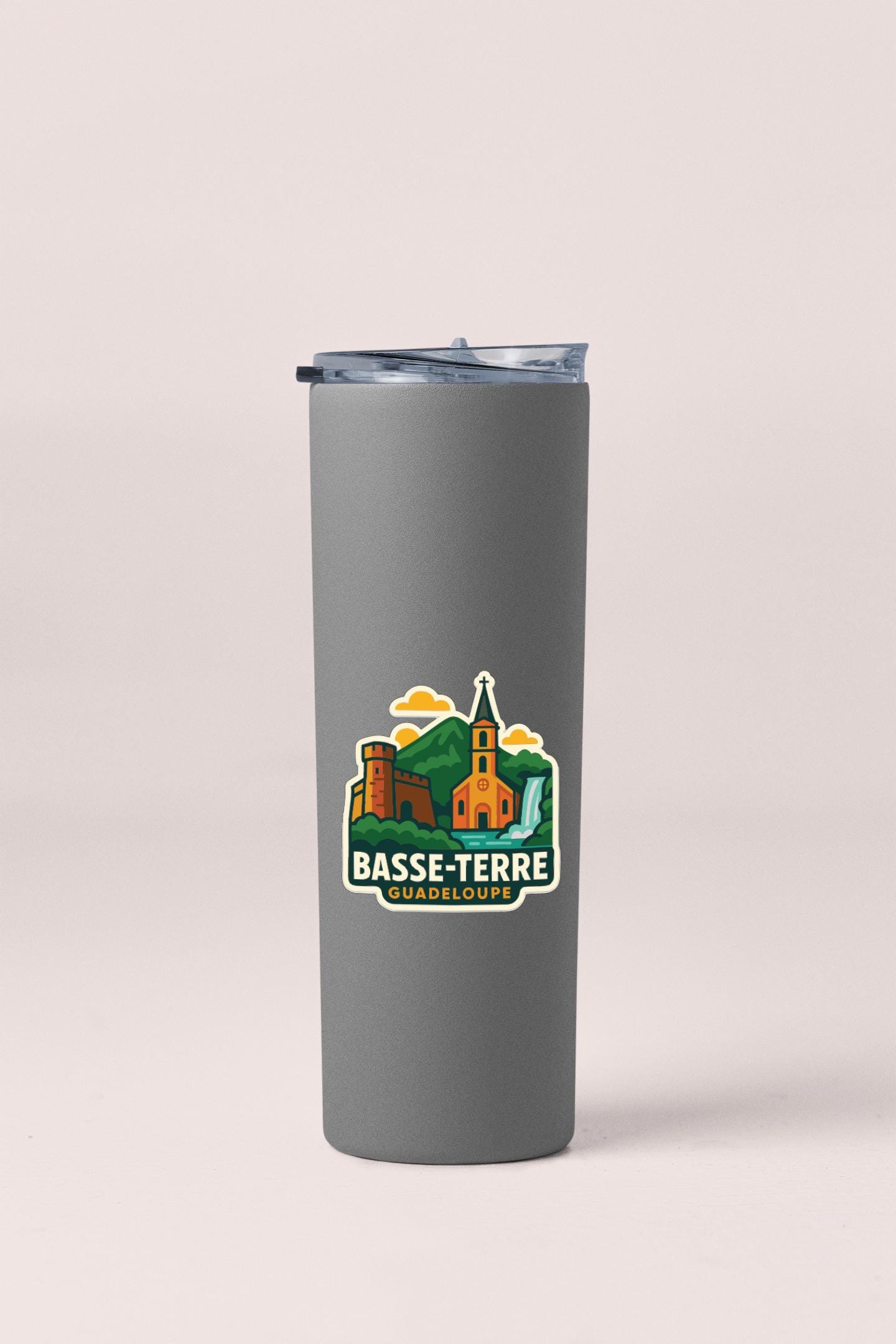 A gray insulated tumbler with a logo depicting a castle and mountains, along with the text "BASSE-TERRE GUADELOUE".