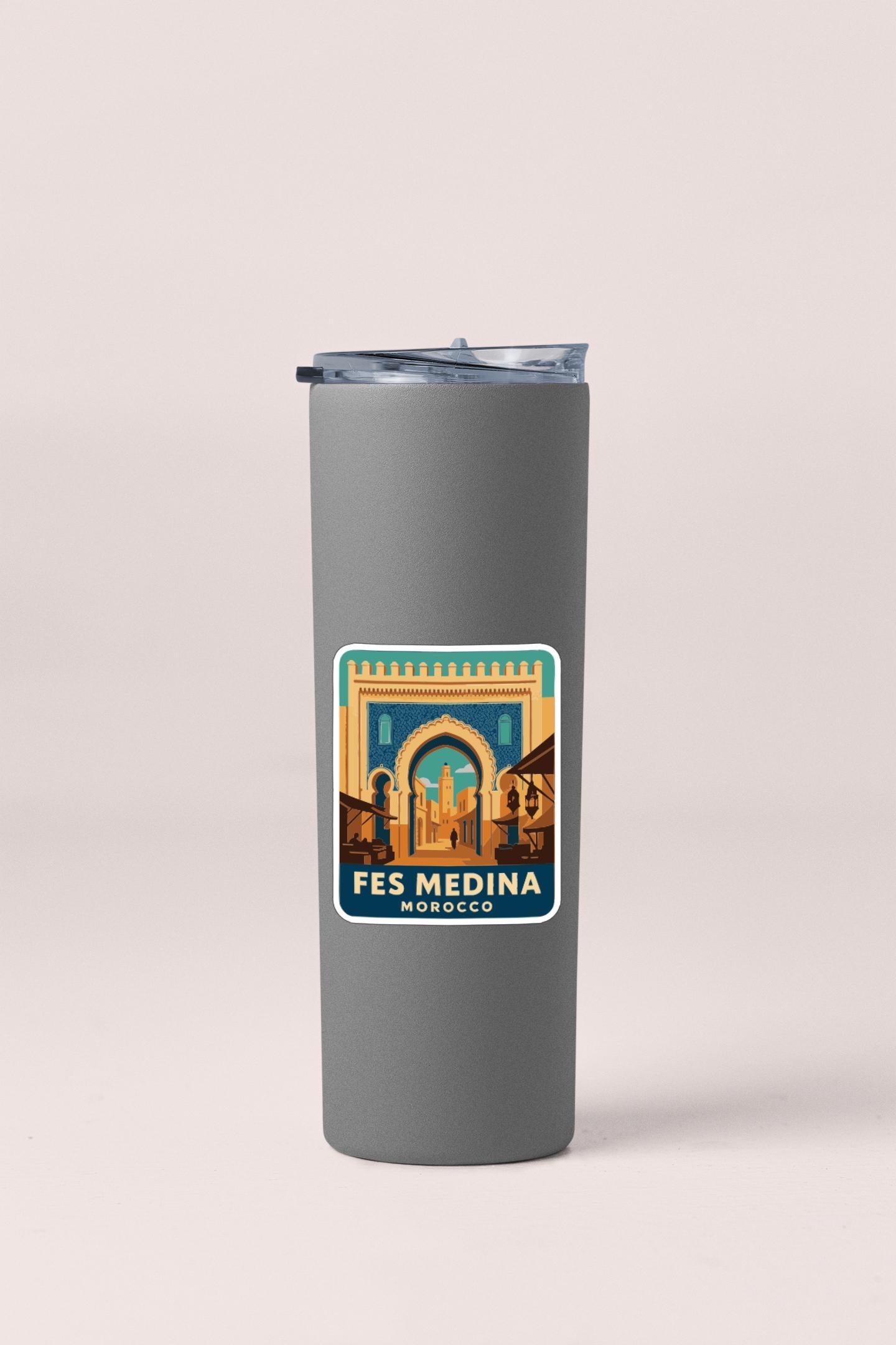 A gray insulated tumbler with a sticker depicting the Fes Medina in Morocco.