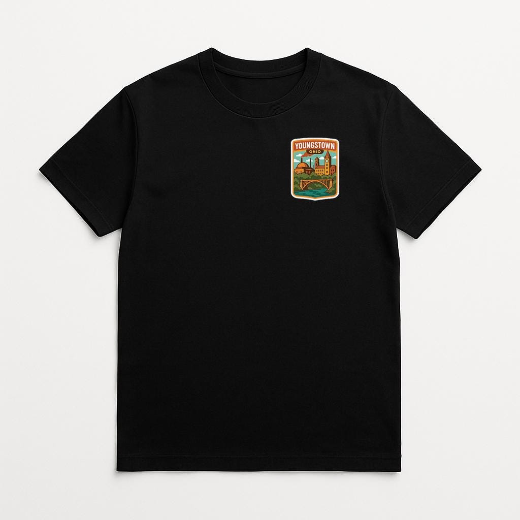 A black t-shirt with a small, colorful patch on the front that says "YOURTOWN".