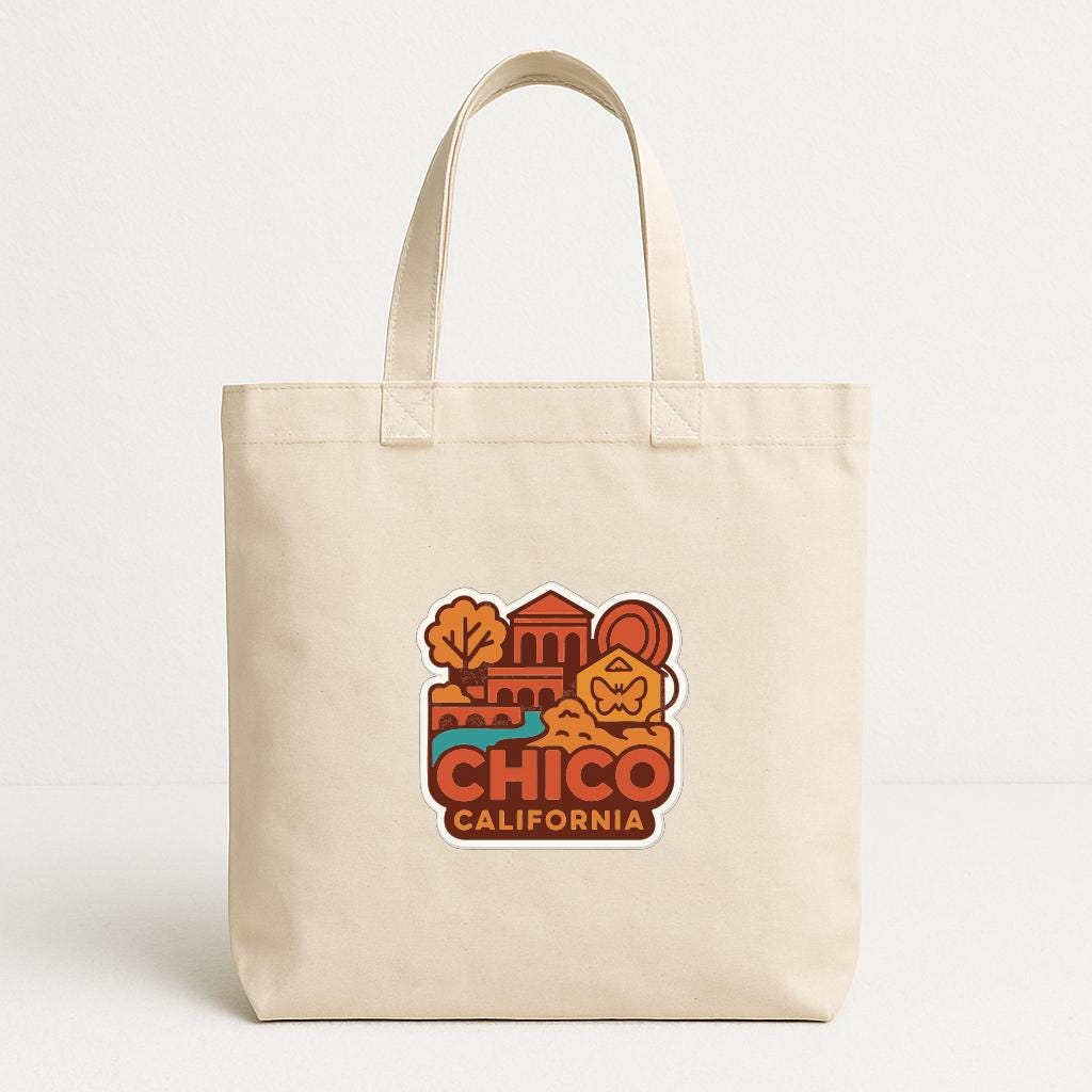 A beige tote bag with a printed design featuring a cityscape and the text "CHICO, CALIFORNIA" printed on it.