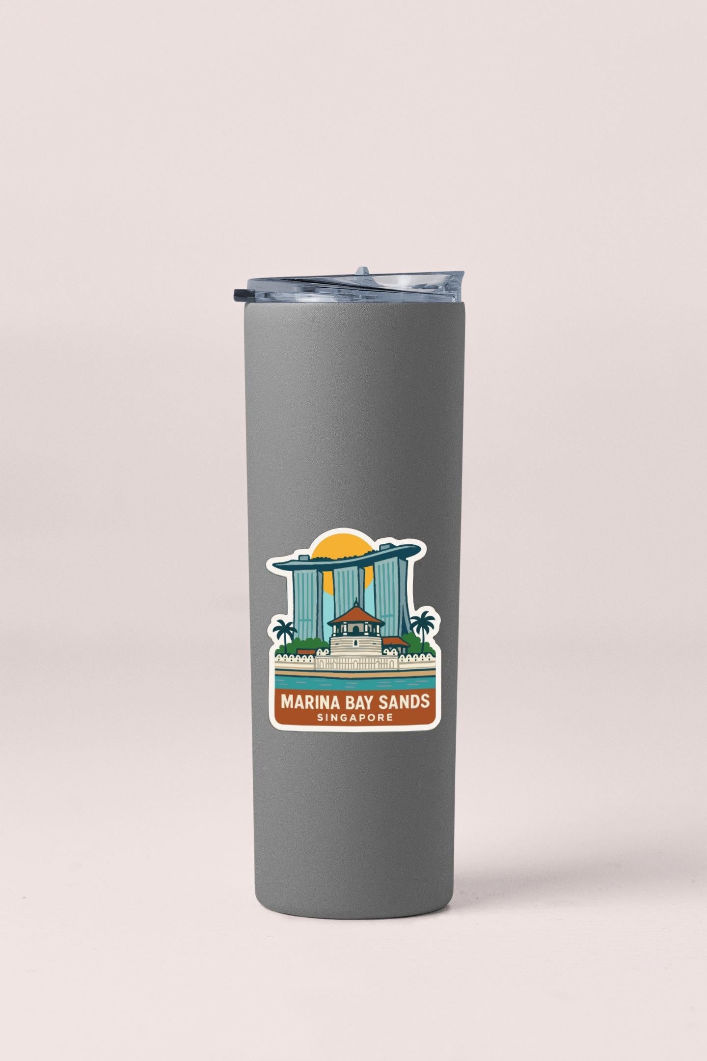 A gray tumbler with a sticker depicting Marina Bay Sands in Singapore.