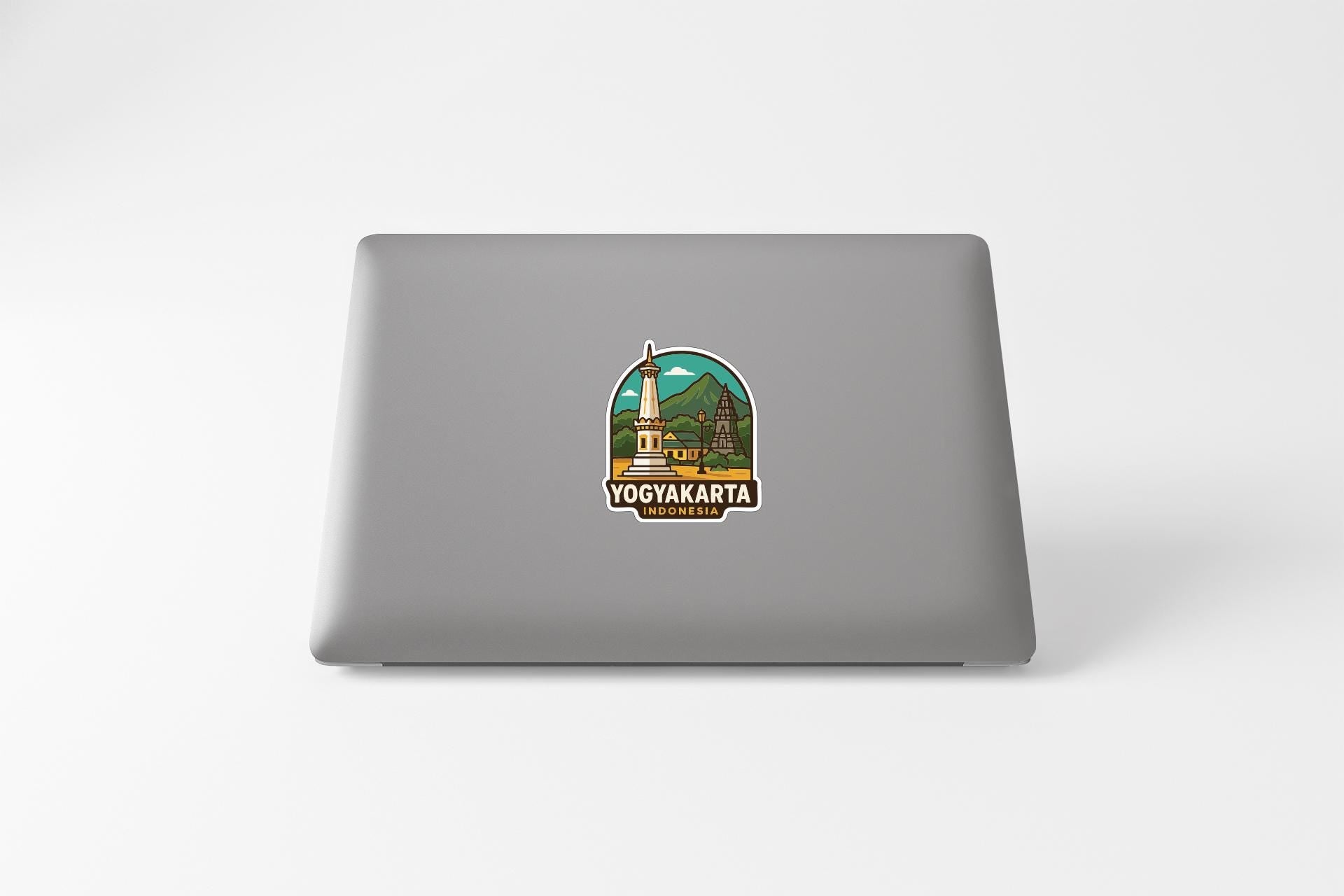 a sticker on the back of a laptop, depicting a cityscape with a mountain in the background.