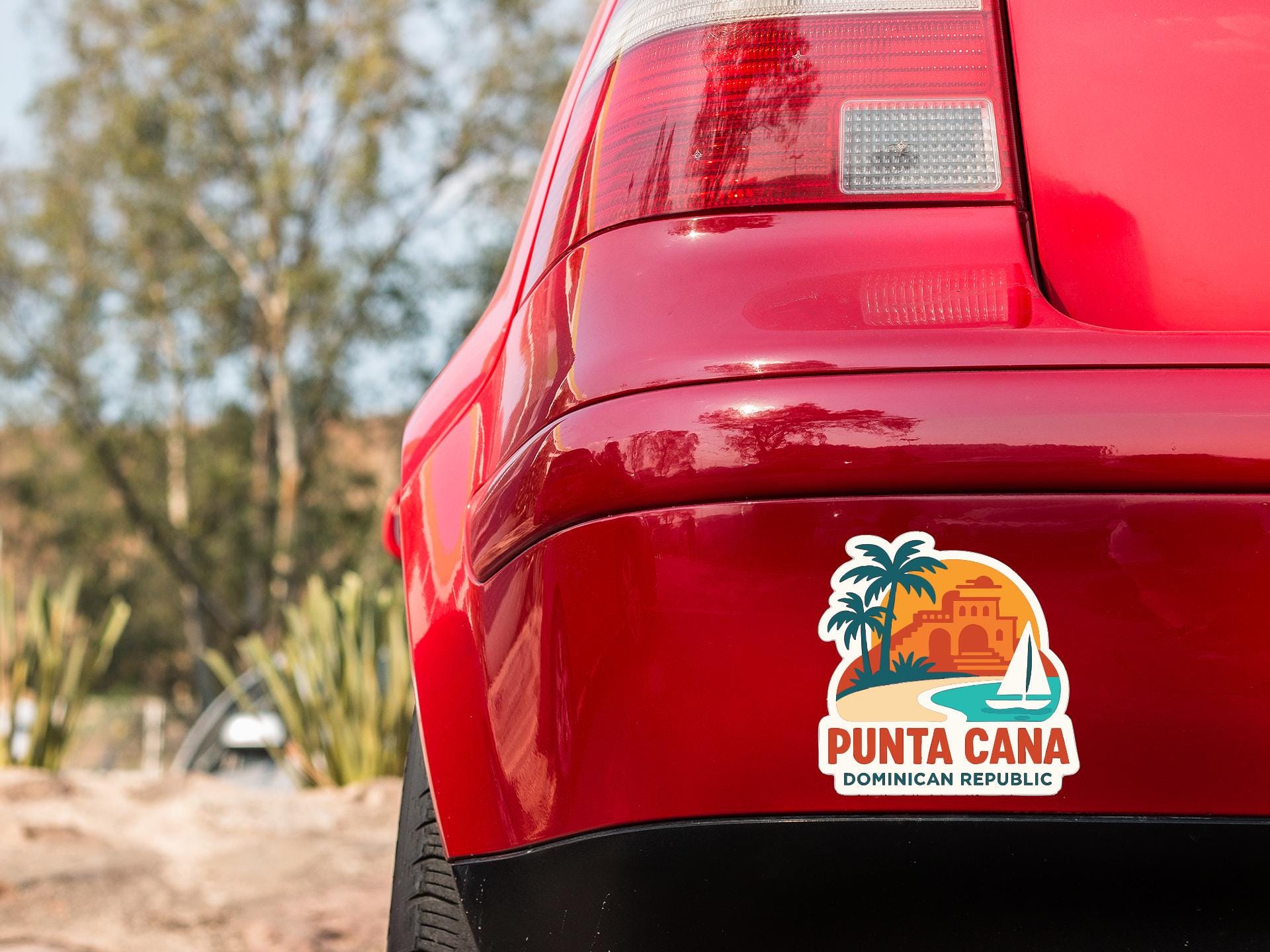 the rear end of a red car with a sticker on the trunk that says "Punta Cana Dominican Republic".