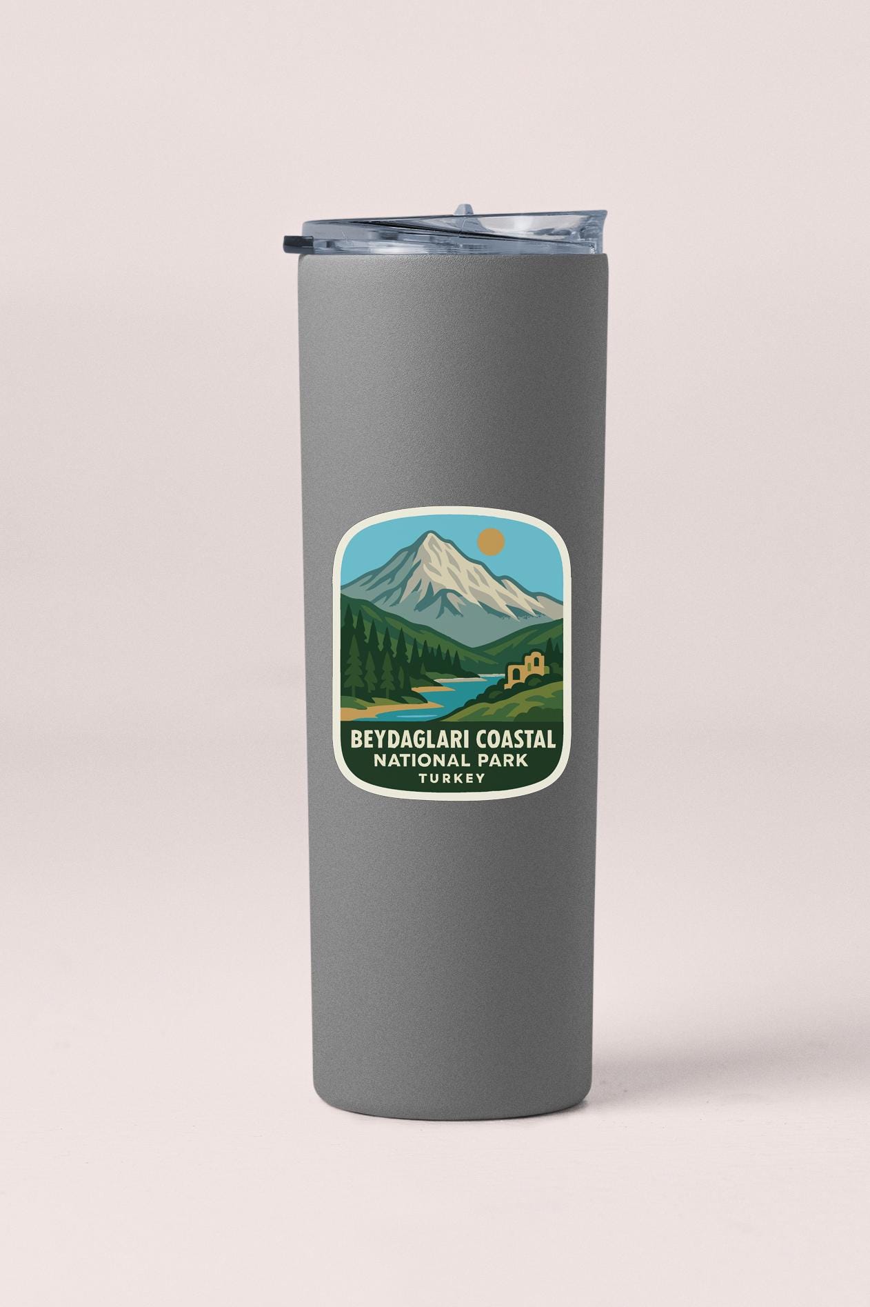 A gray insulated tumbler with a sticker depicting a mountain landscape and the text "BEYDAGALARI COASTAL NATIONAL PARK TURKEY".
