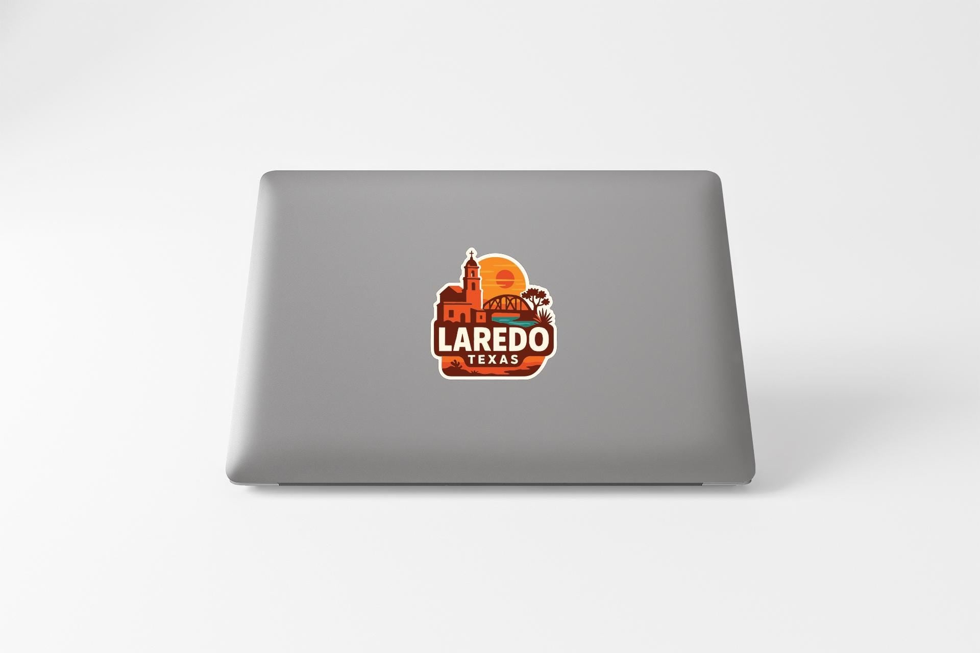 a sticker with the text "LAREDO TEXAS" on the back of a laptop.