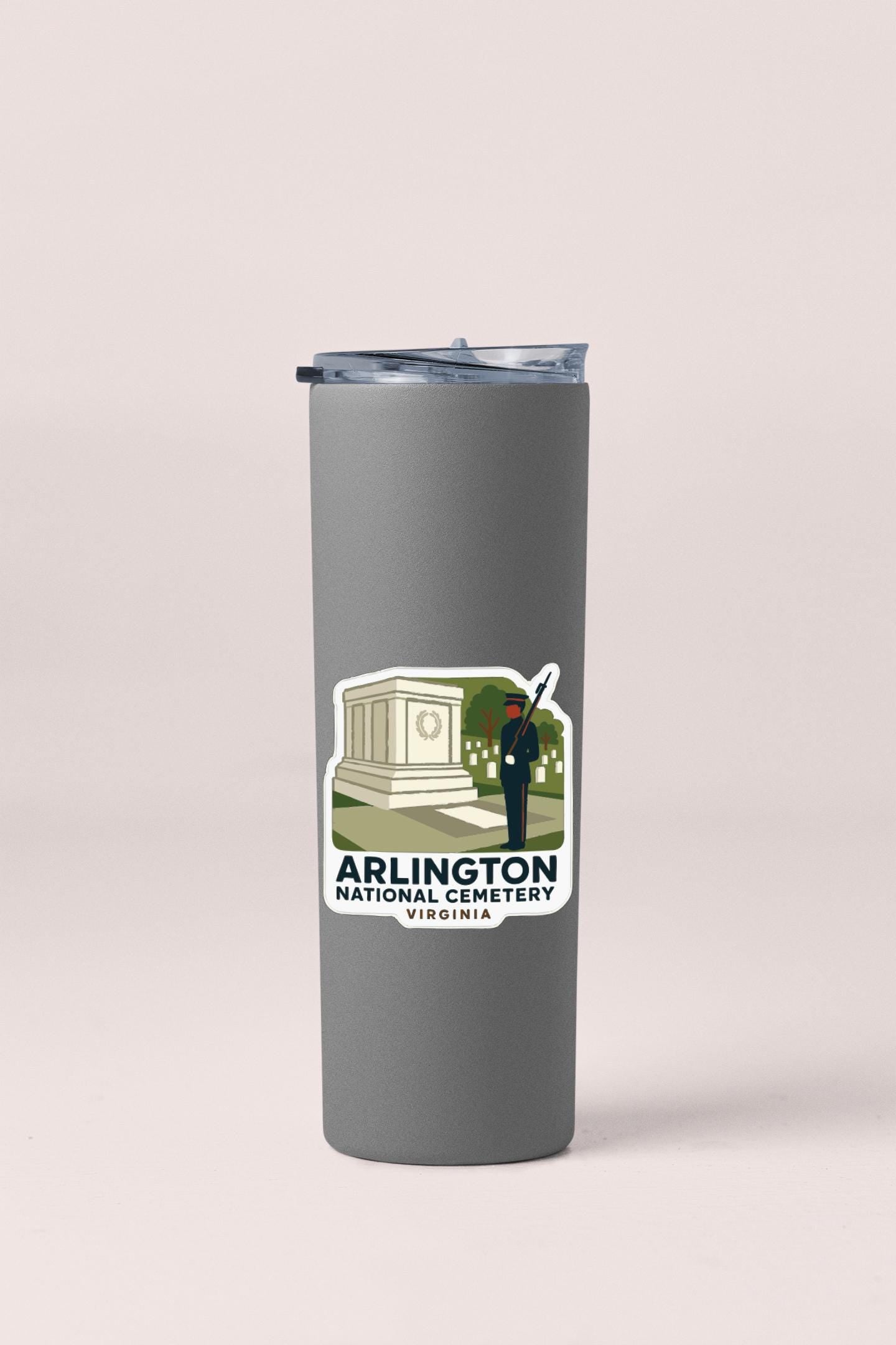 A gray tumbler with a sticker depicting the Arlington National Cemetery in Virginia.
