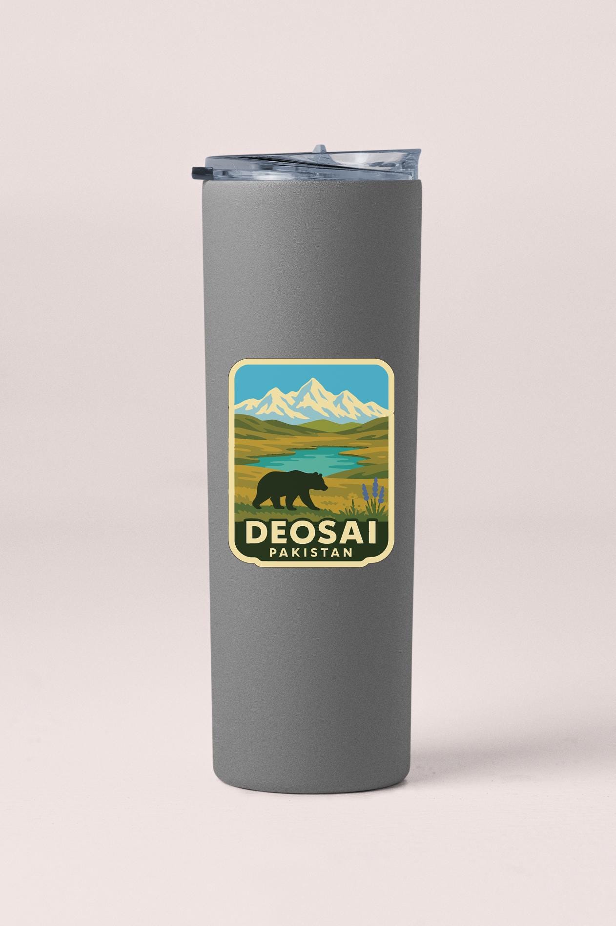 A gray insulated tumbler with a sticker depicting a bear in a mountainous landscape and the text "DEOSAI PARISAN" printed on it.