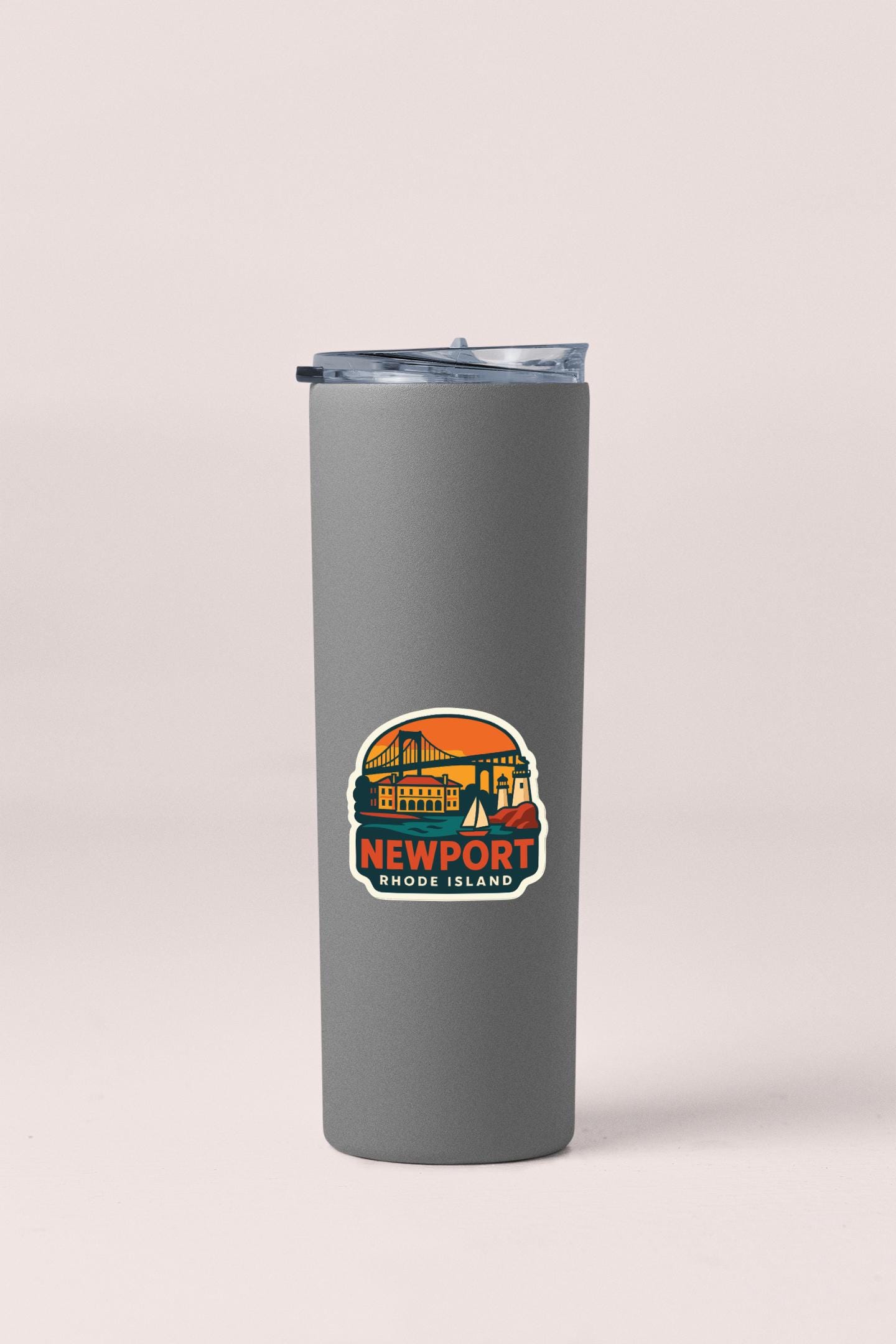 A gray insulated tumbler with a lid and a sticker depicting a scenic view of Newport, Rhode Island.
