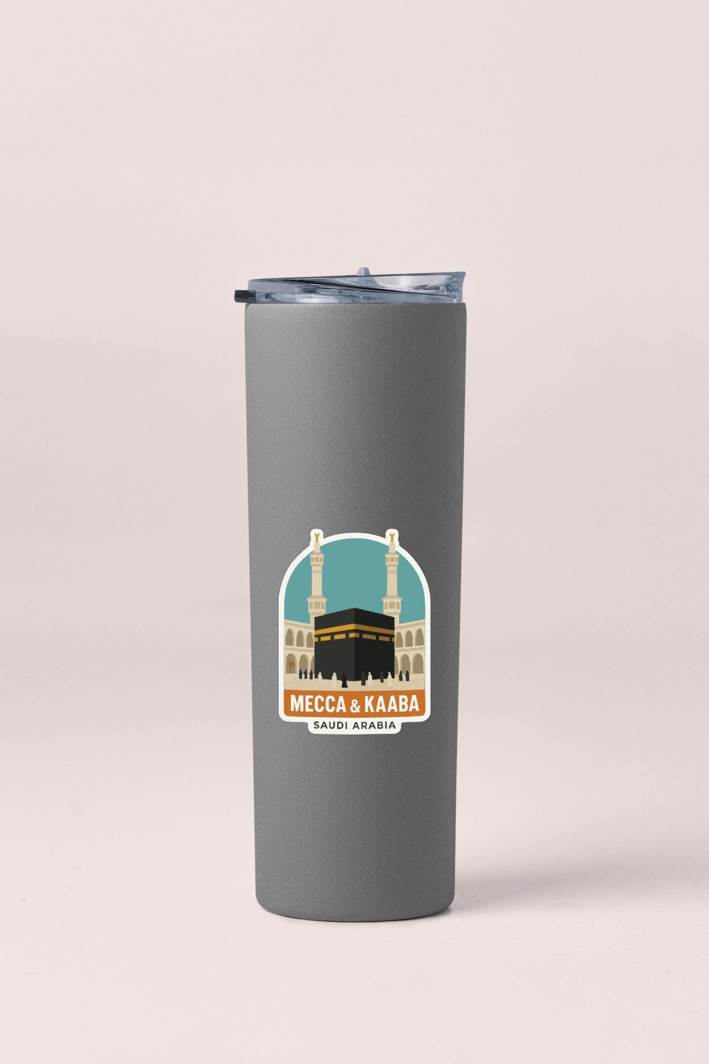 A gray tumbler with a sticker depicting Mecca and Kaaaba, which is the holy site of Islam.