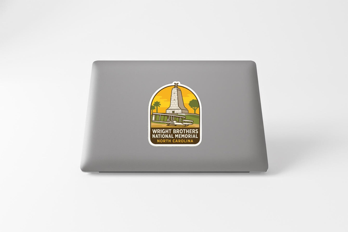 A sticker on the back of a laptop, depicting a tall structure with a palm tree in the background.