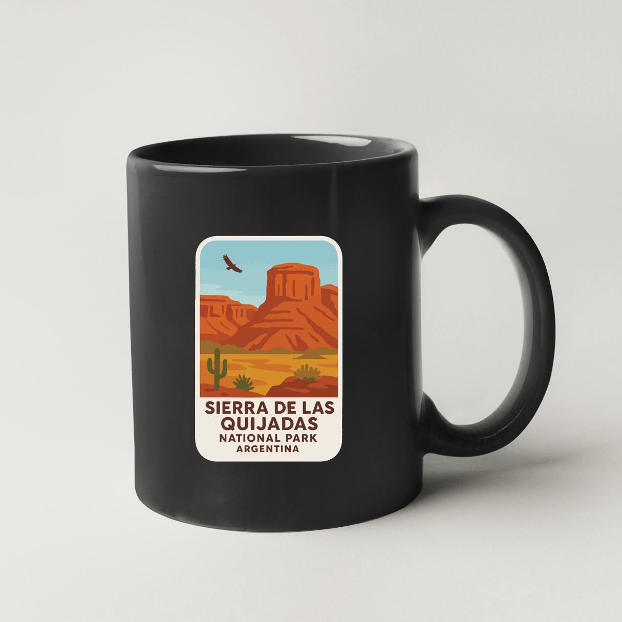 A black coffee mug with a graphic design depicting the Sierra de Las Quijadas National Park in Argentina.