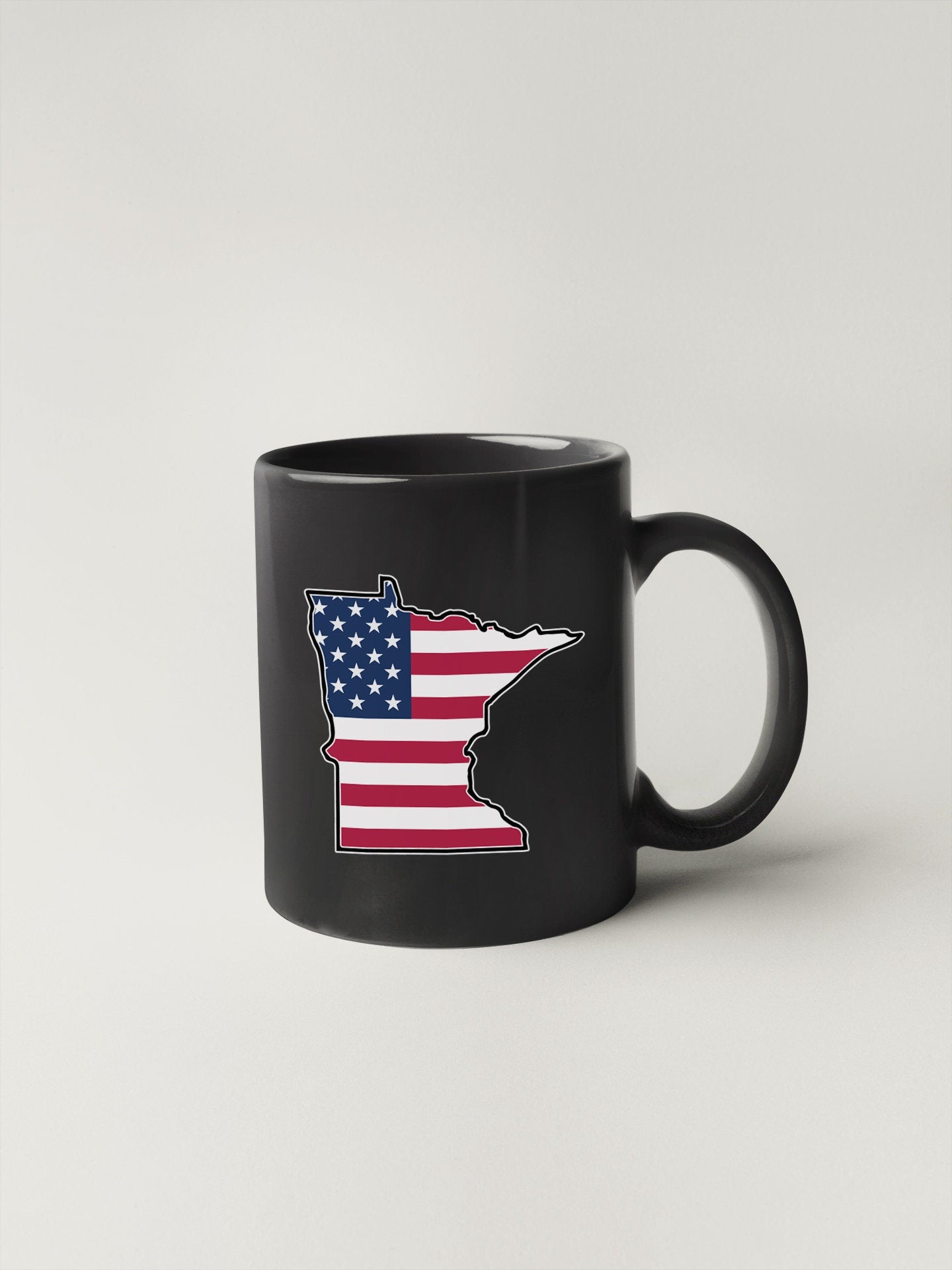 a black coffee mug with the state of minnesota painted on it