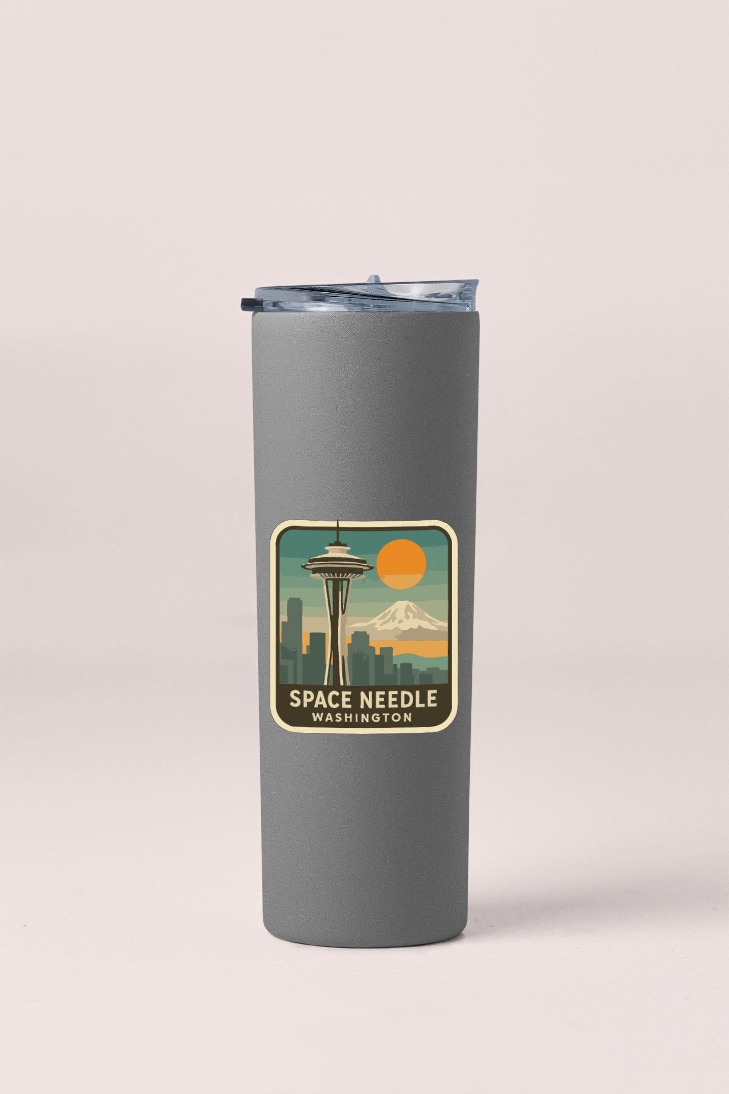 A gray insulated tumbler with a sticker depicting the Space Needle in Seattle, Washington.