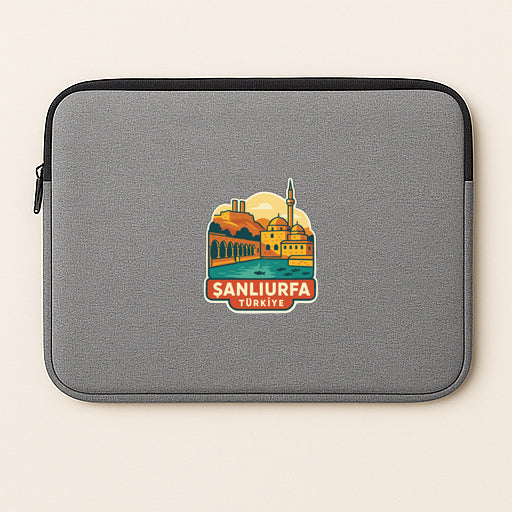 A gray laptop sleeve with a sticker depicting a cityscape and the text "Sanlufa, Turkey".