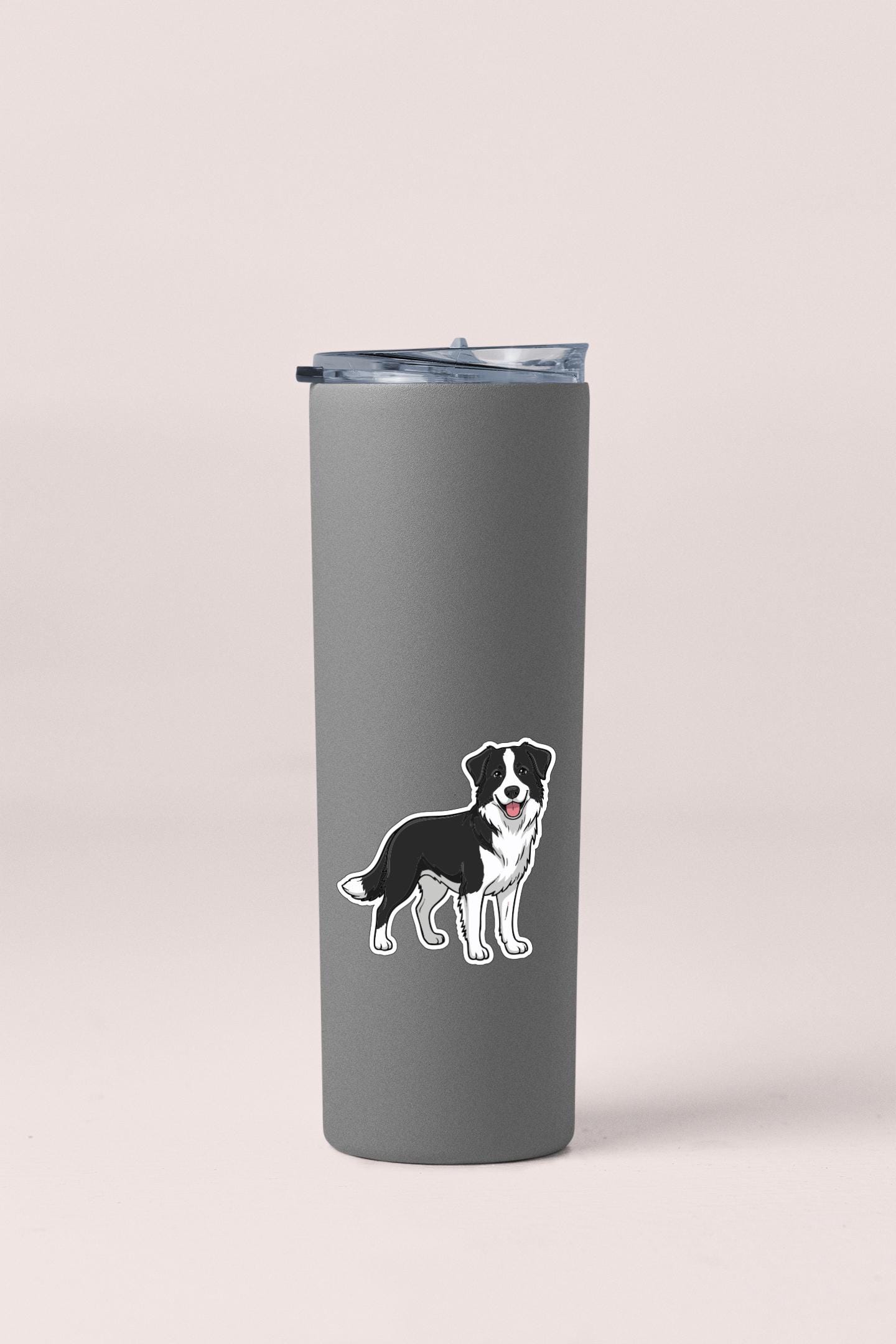 A gray insulated tumbler with a black and white dog sticker on it.