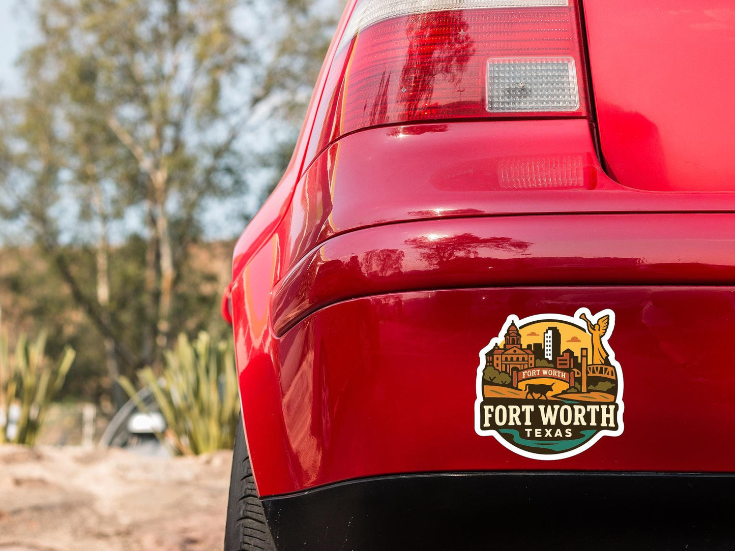 the rear end of a red car with a sticker on the trunk that says "Fort Worth, Texas".