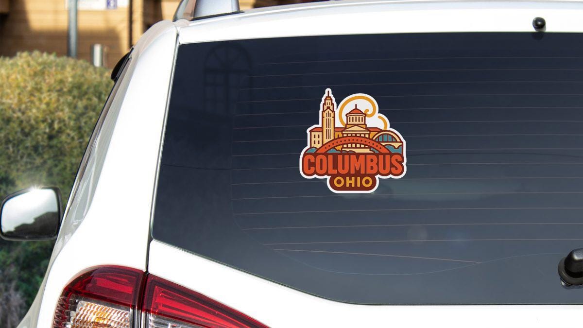 a sticker on the rear window of a white vehicle, featuring the city of Columbus, Ohio.