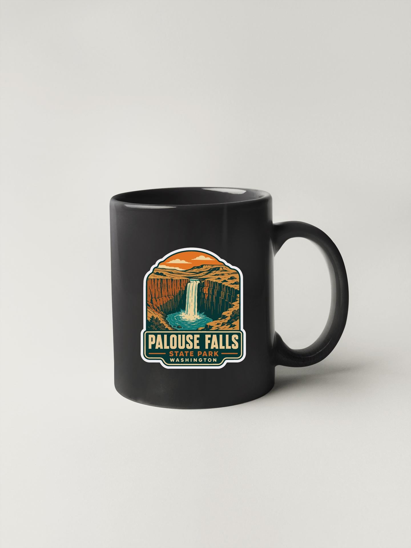 A black coffee mug with a graphic design depicting the scenic falls of Palouse Falls in Washington.