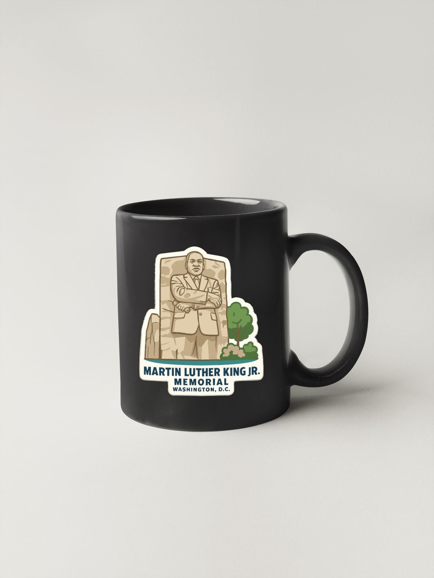 A black coffee mug with a graphic design depicting Martin Luther King Jr. and the Washington Monument.