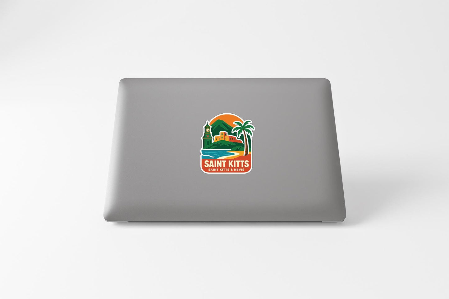 a sticker with a tropical beach scene and a lighthouse, placed on the back of a laptop.