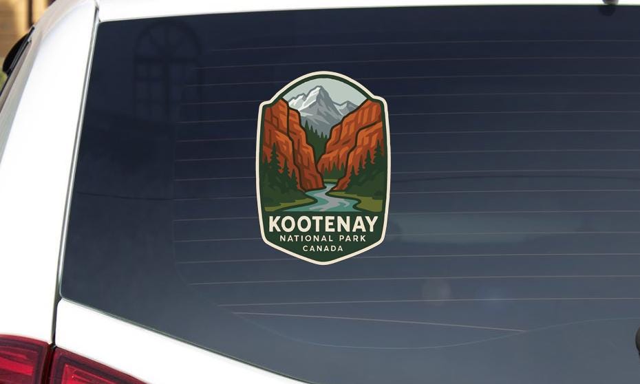 A sticker on the rear window of a vehicle displaying the logo and name of Kootenay National Park, Canada.