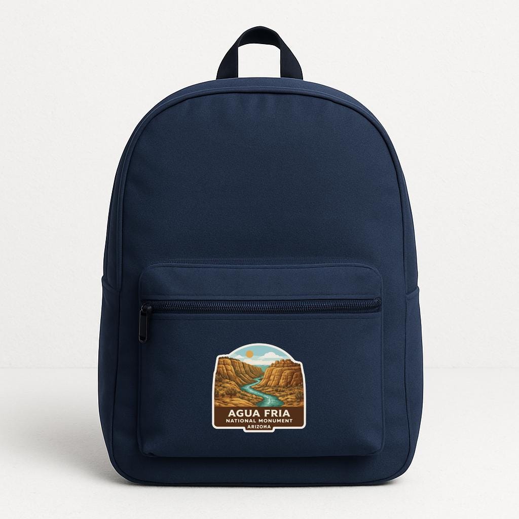 A navy blue backpack with a graphic of a river and mountains on the front pocket.