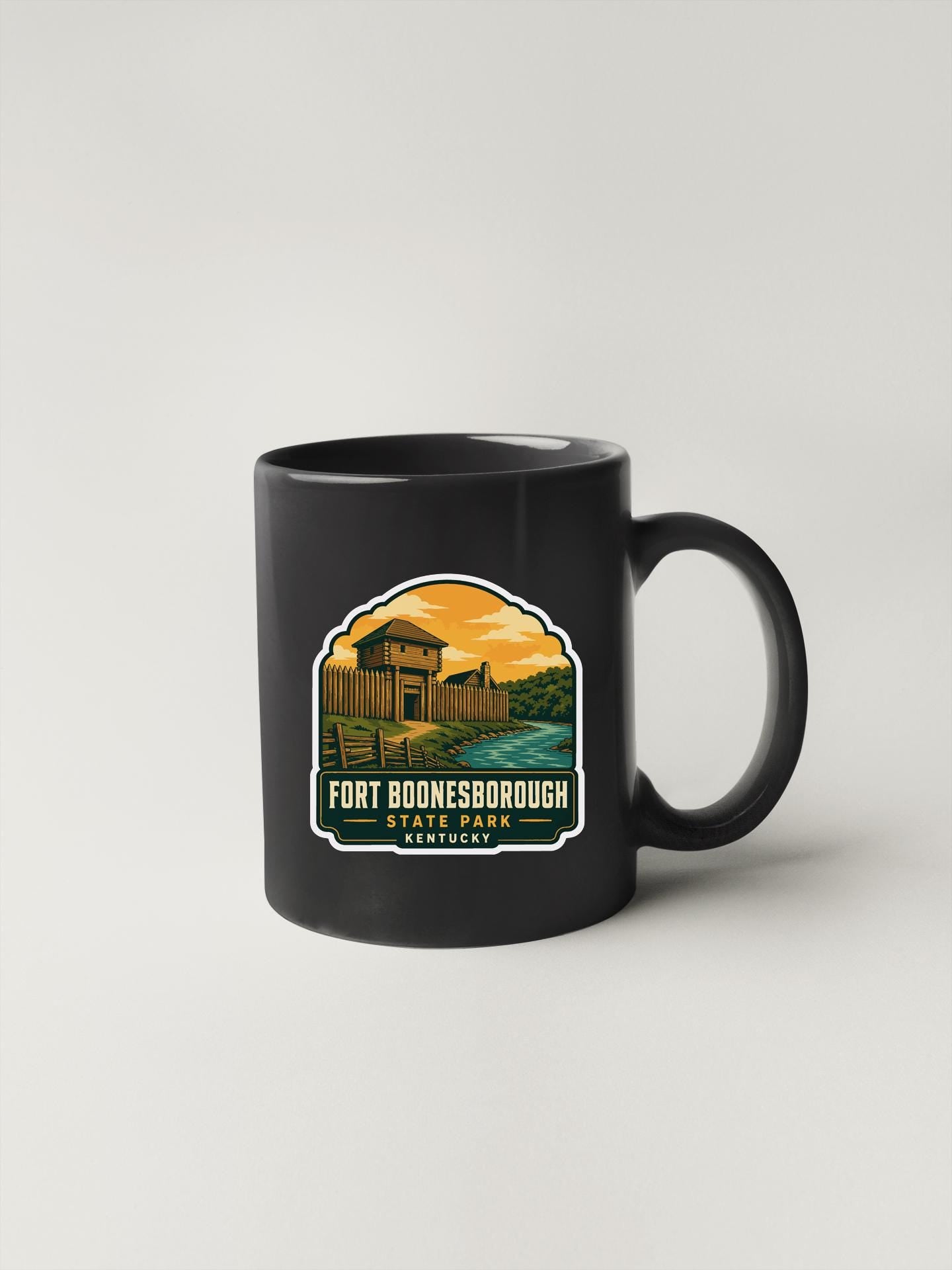 A black coffee mug with a graphic design depicting a scenic landscape featuring a building and a body of water.