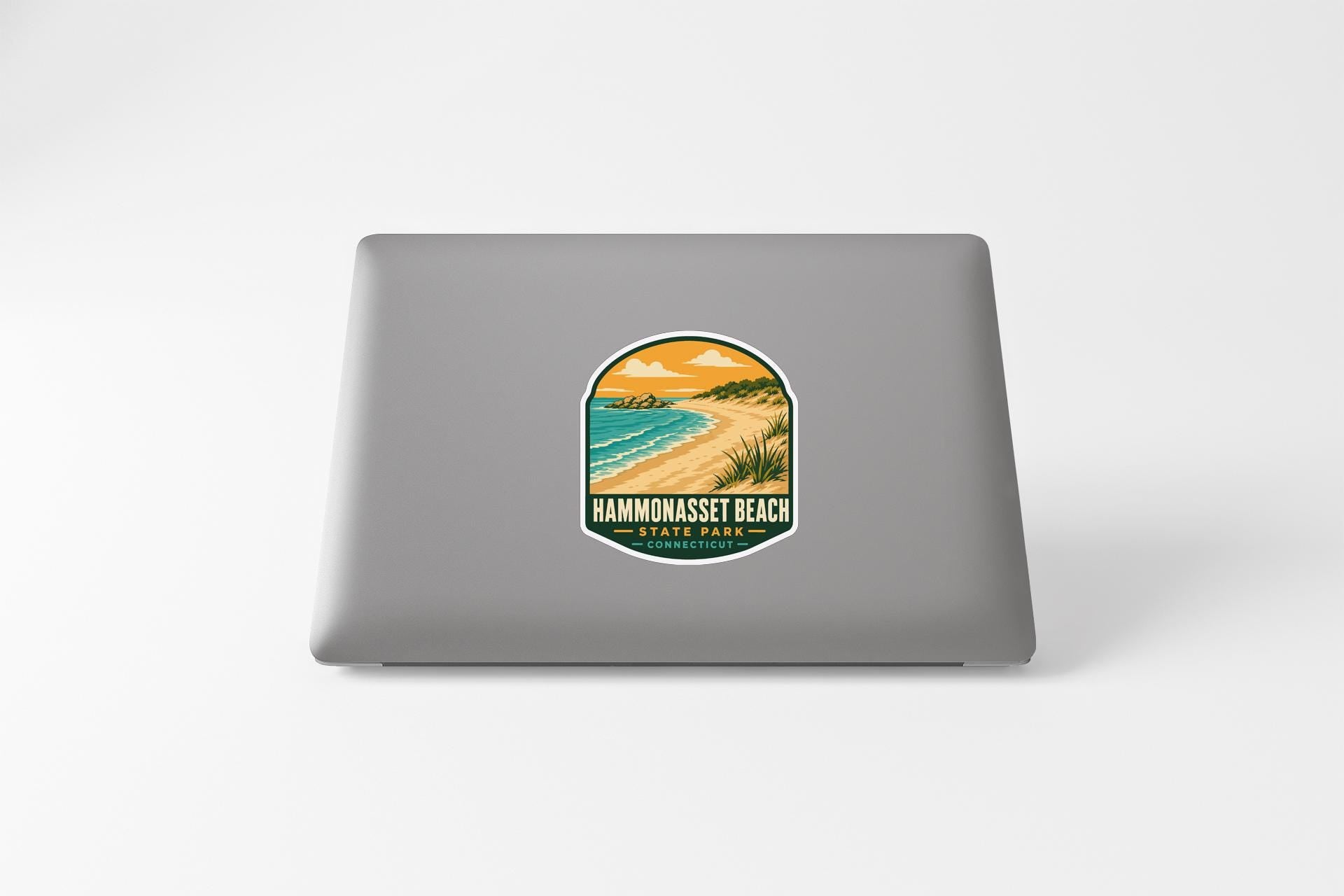 a sticker with a beach scene and the text "BAMMONASET BEACH" printed on a laptop.