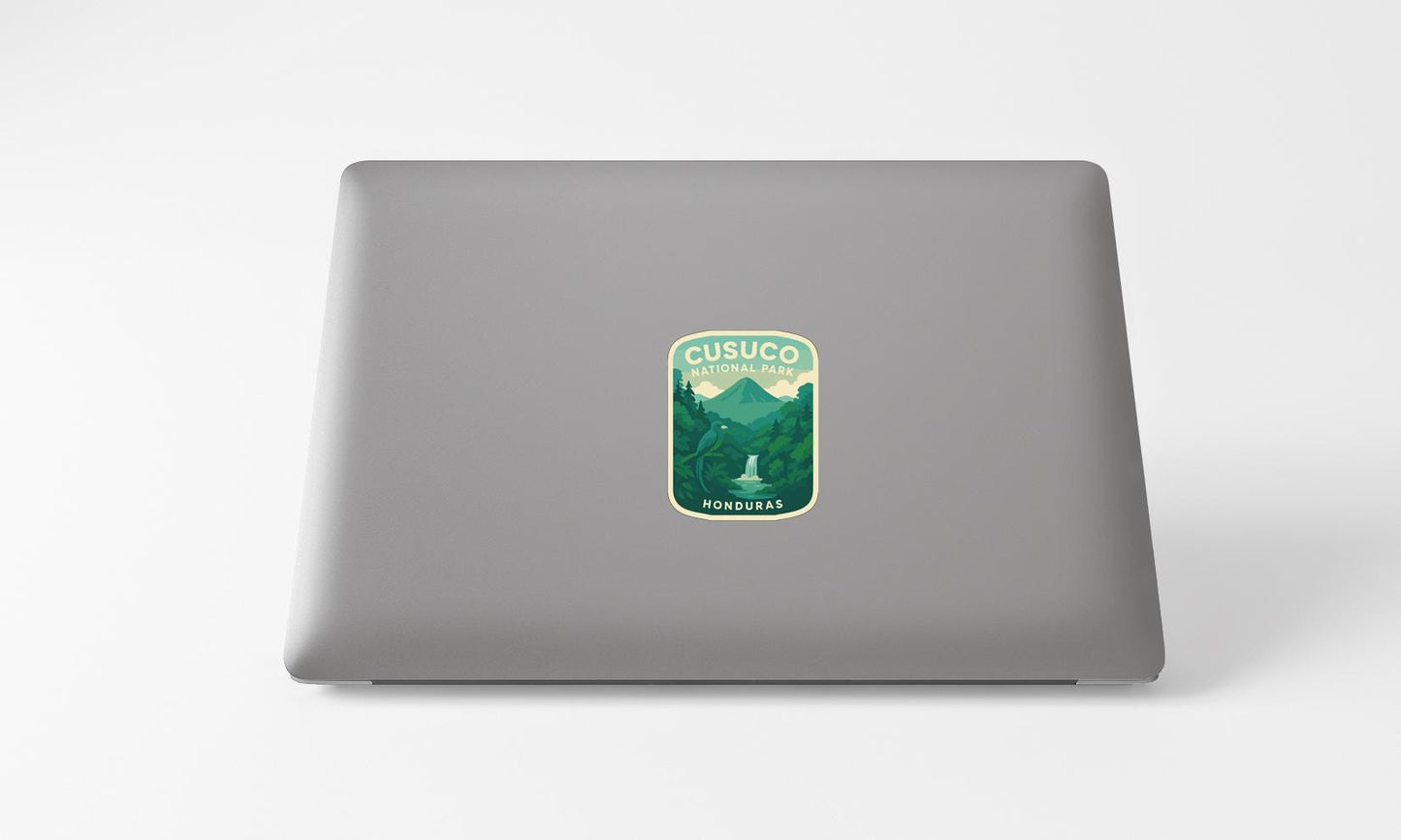 A sticker on the back of a laptop, depicting a mountain landscape with a waterfall.
