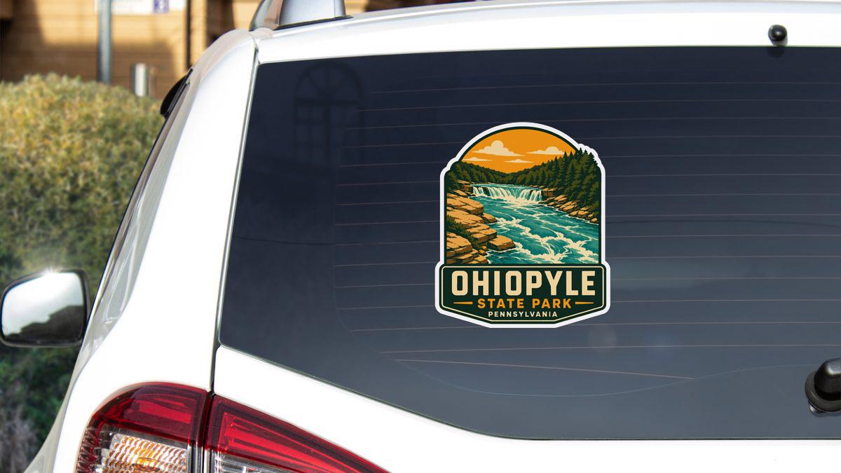 A sticker on the rear window of a white car, depicting a scenic landscape with a waterfall and forest.