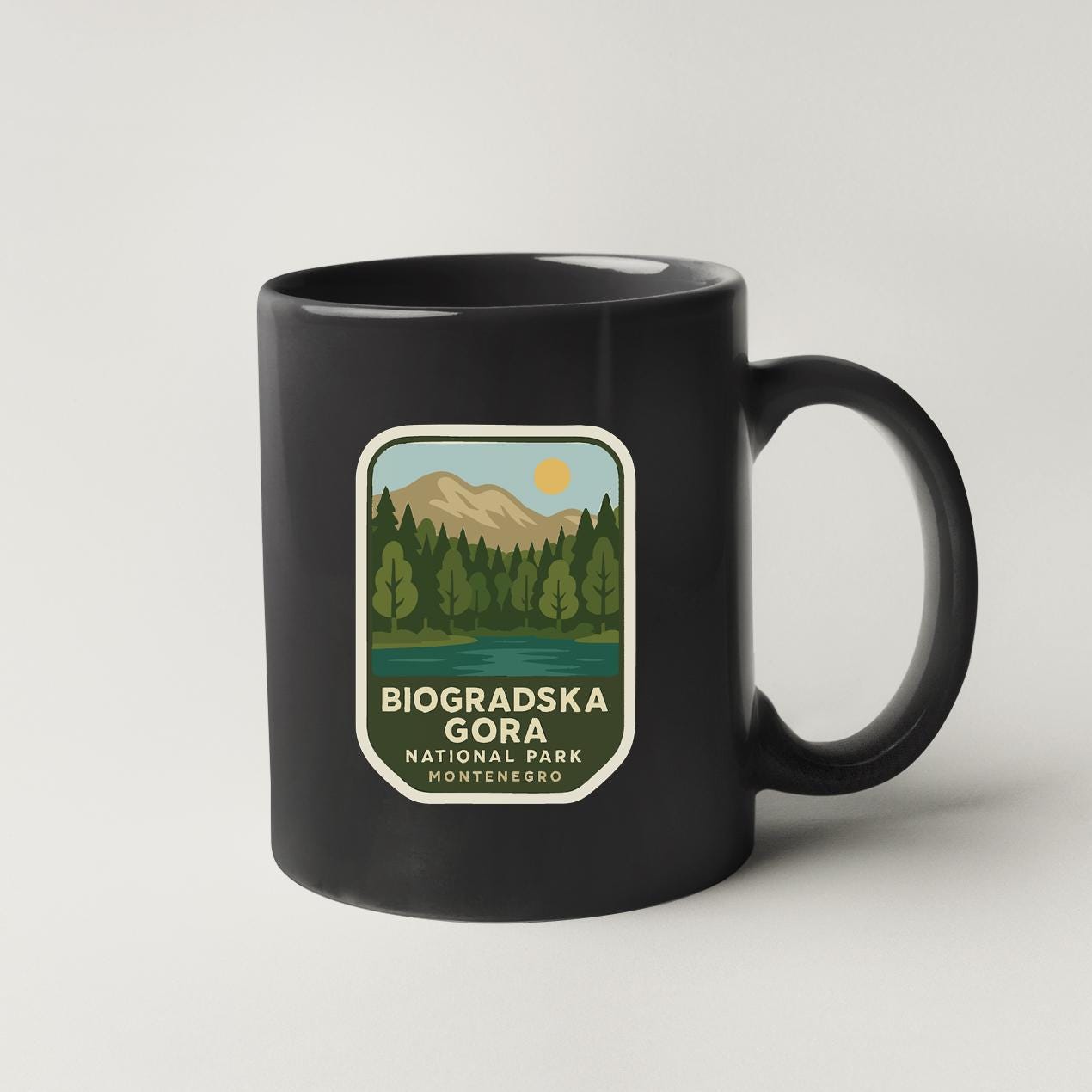 A black coffee mug with a label that says "BIOGRADSKA GORA NATIONAL PARK MONTENEREIRO".