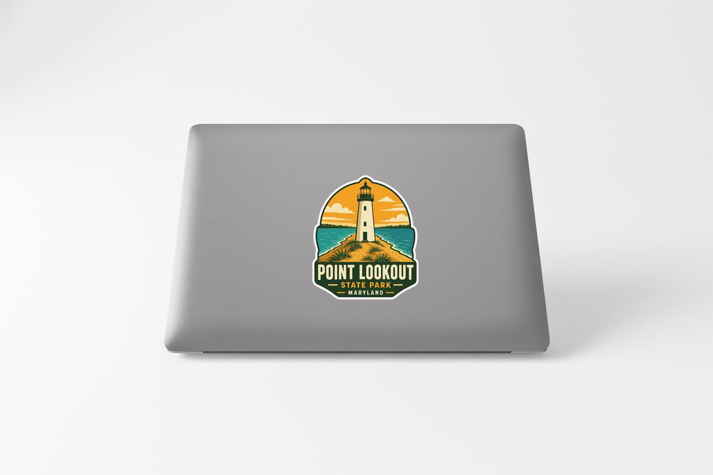a sticker with a lighthouse and a beach scene on a laptop.