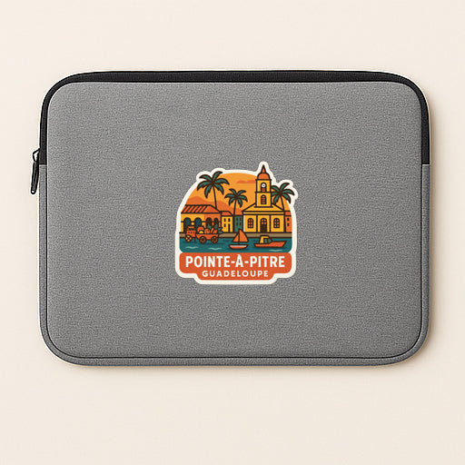 A gray laptop sleeve with a sticker depicting a tropical island scene and the text "Pointe-a-Pire Guadeloupe".
